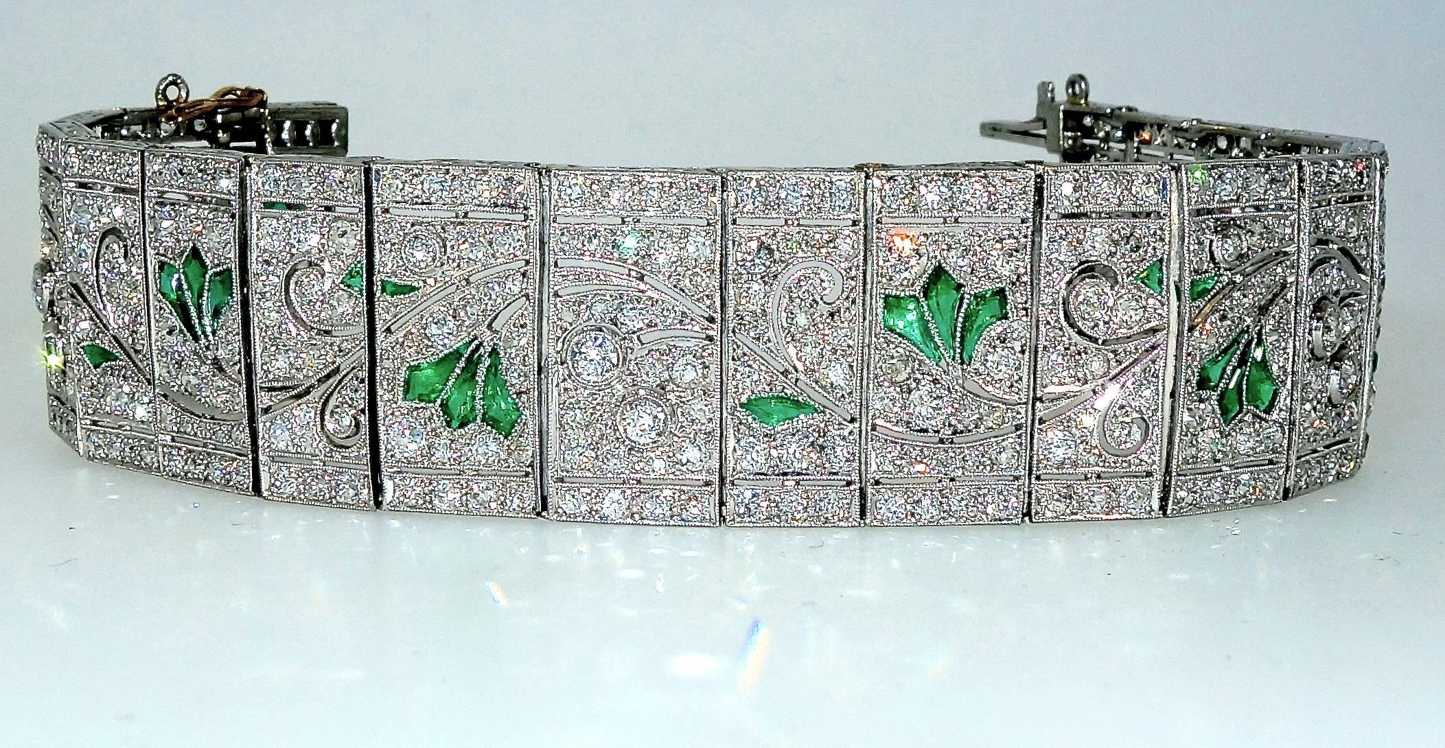 Fancy cut bright green emeralds are set throughout this wide band bracelet in a leaf and flower design within a "field" of diamonds. Notice how graceful the open platinum work has been executed to give the viewer the idea of movement!  