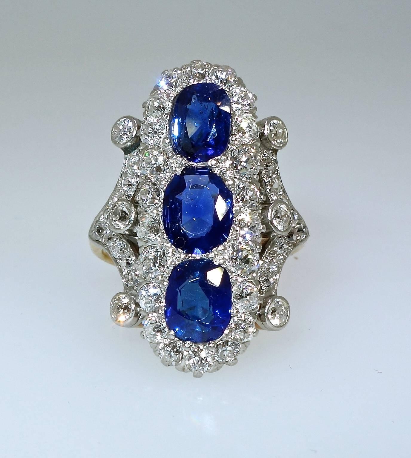The three, probably from Burma, sapphires are all natural, unheated, and display very fine color.  The are surrounded by European cut diamonds - all well cut, white (H) and very slightly included (VS).  This platinum ring is simply beautiful and a
