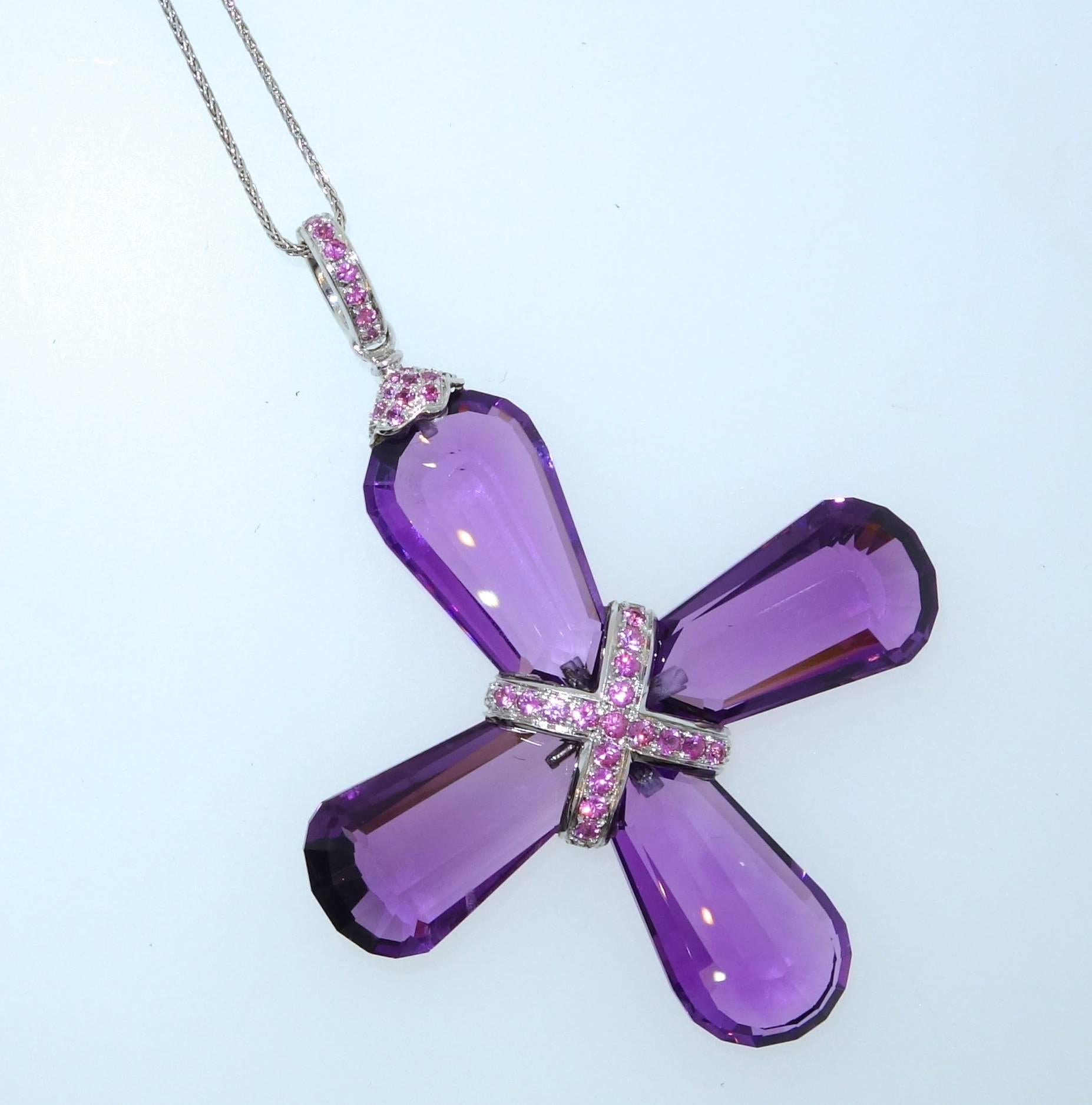 The four fancy cut fine natural large amethyst come together to create an unusual cross.  One side are white diamonds, the other side are  pink sapphires.  There are approximately approximately 50 cts of fine clean fancy cut amethysts.  There are 38