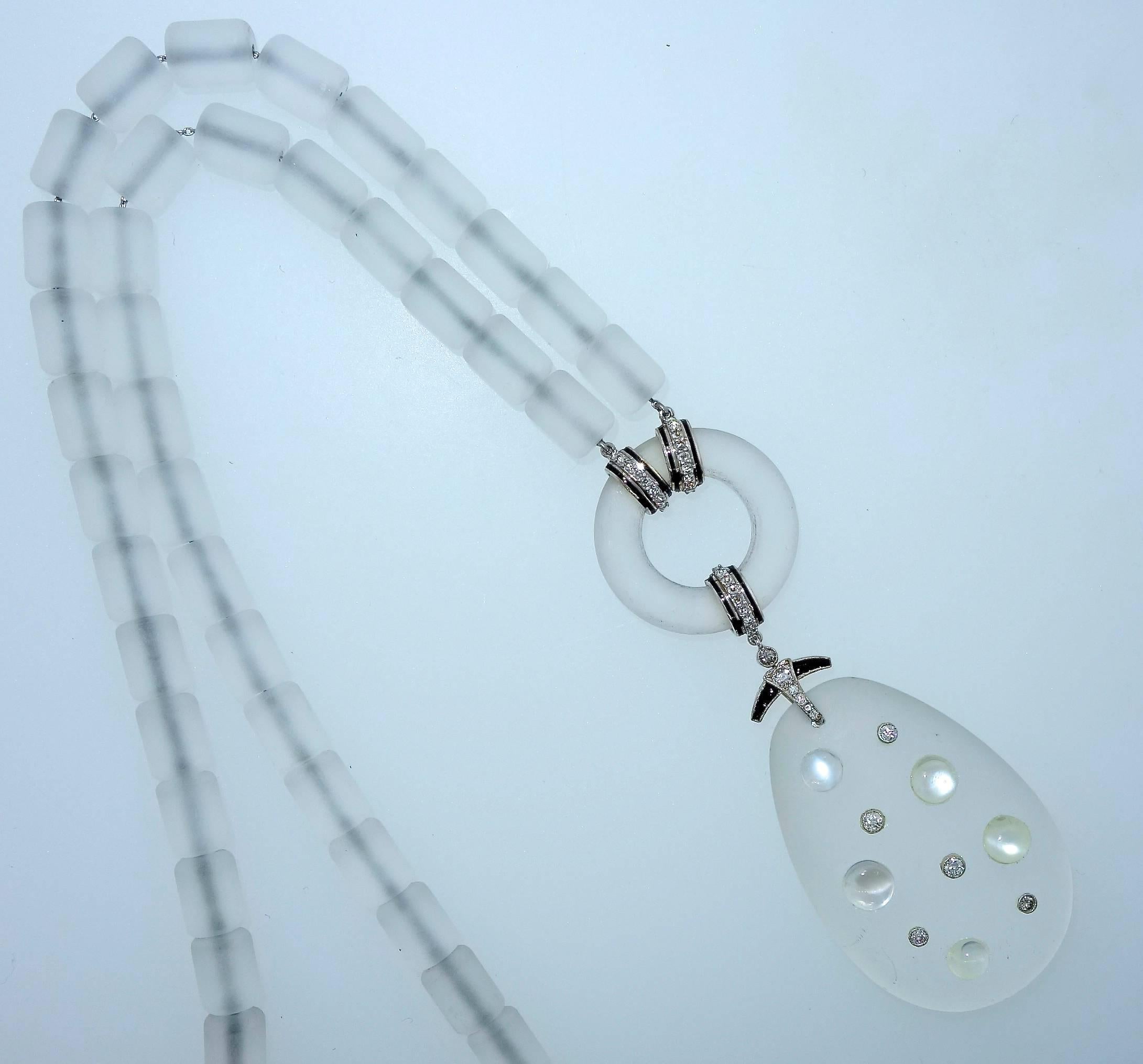 Early 20th century French design, blanc de blanc, platinum necklace.  The tear drop frosted rock crystal pendant portion is set with moonstone and old cut diamonds.  It is suspended from  black enamel, onyx and old cut diamonds.   The rock crystal