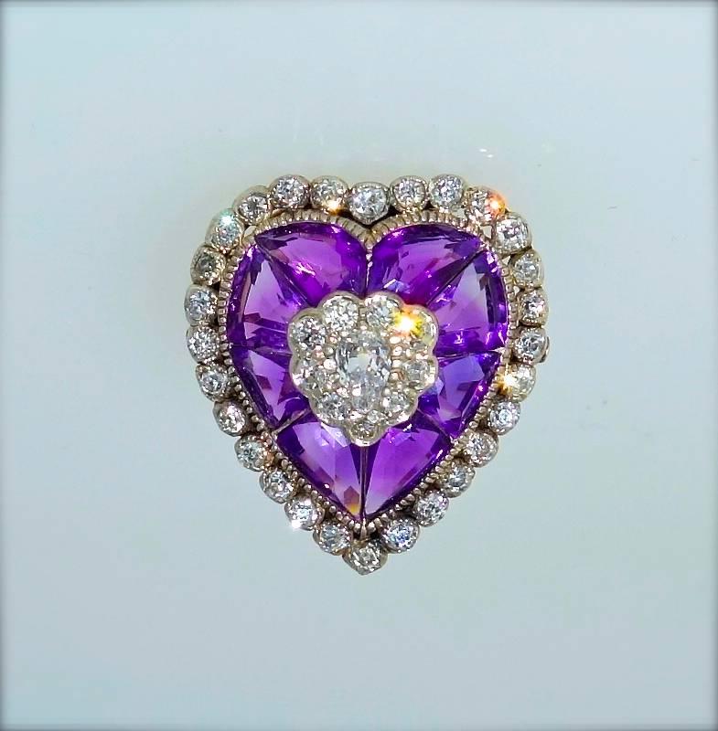 Heart shaped antique ring in gold and silver (which was the classic metals used in the 19th century before platinum was invented) centering an old cut pear cut diamonds with  mine cut diamonds surrounding.  The unusual fancy cut amethysts are quite