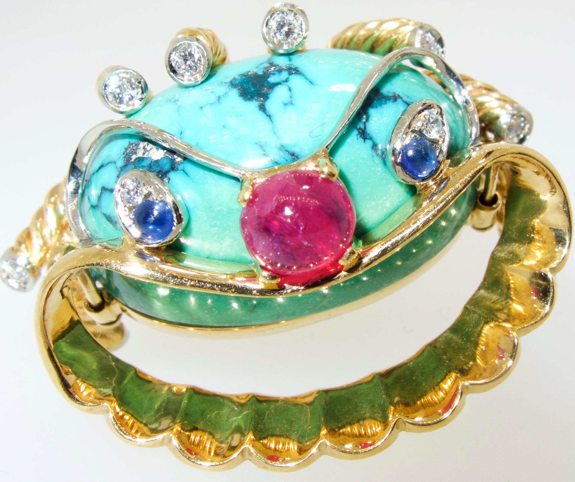 18K circa 1960 clown motif brooch with a ruby nose, sapphire and diamond eyes, turquoise head and diamonds at the end of his hair which which are hinged in such a way so that the tendrils move.  The brooch is 1.5 inches by 1.25 inches.  This amusing