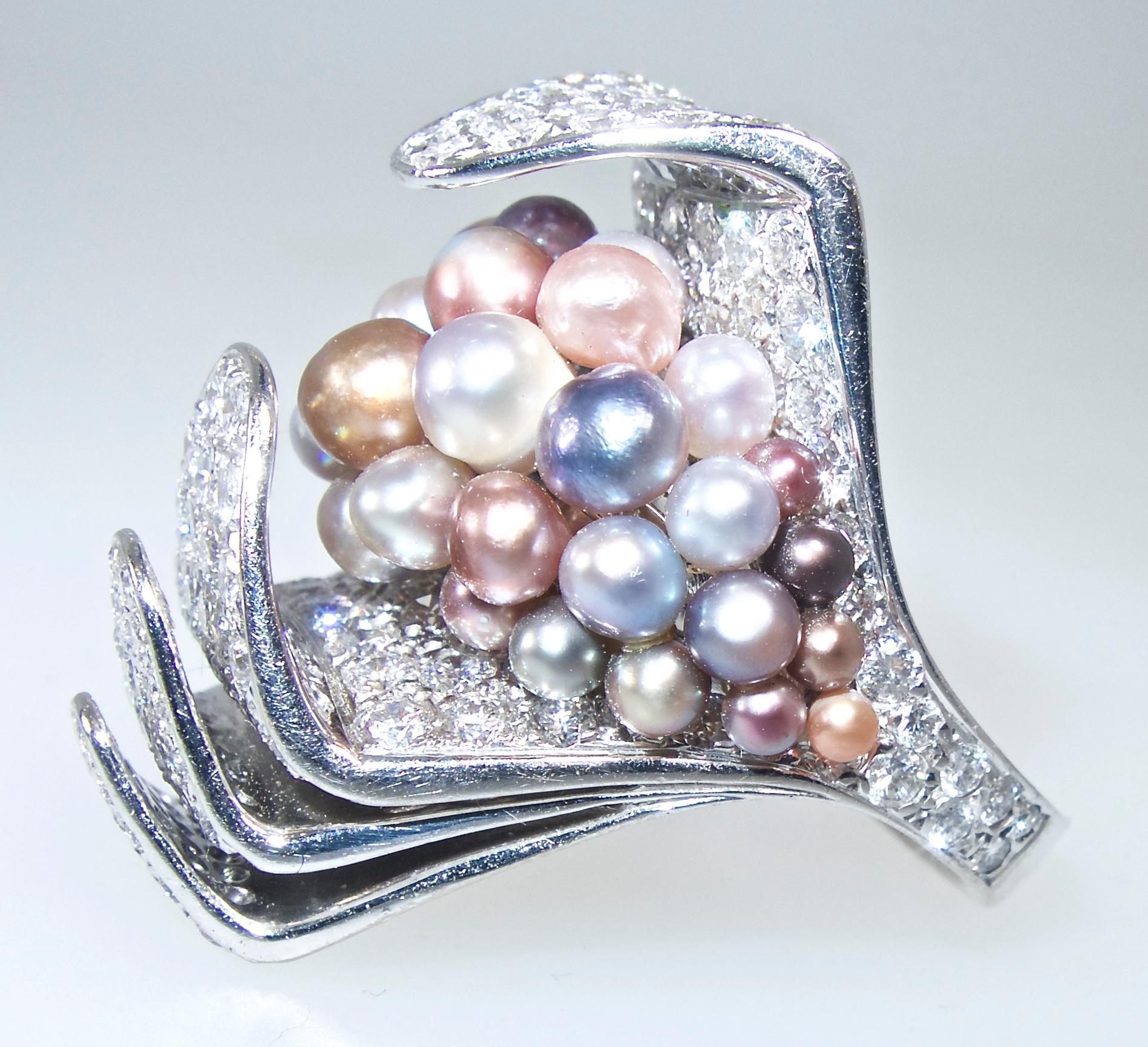 Natural pearls and white diamonds (F) and very very slightly included (VVS) come together to create an outstanding and highly unusual 18K white gold ring.  Large and bold in design.  The 38  fine natural salt water pearls of various colors all have