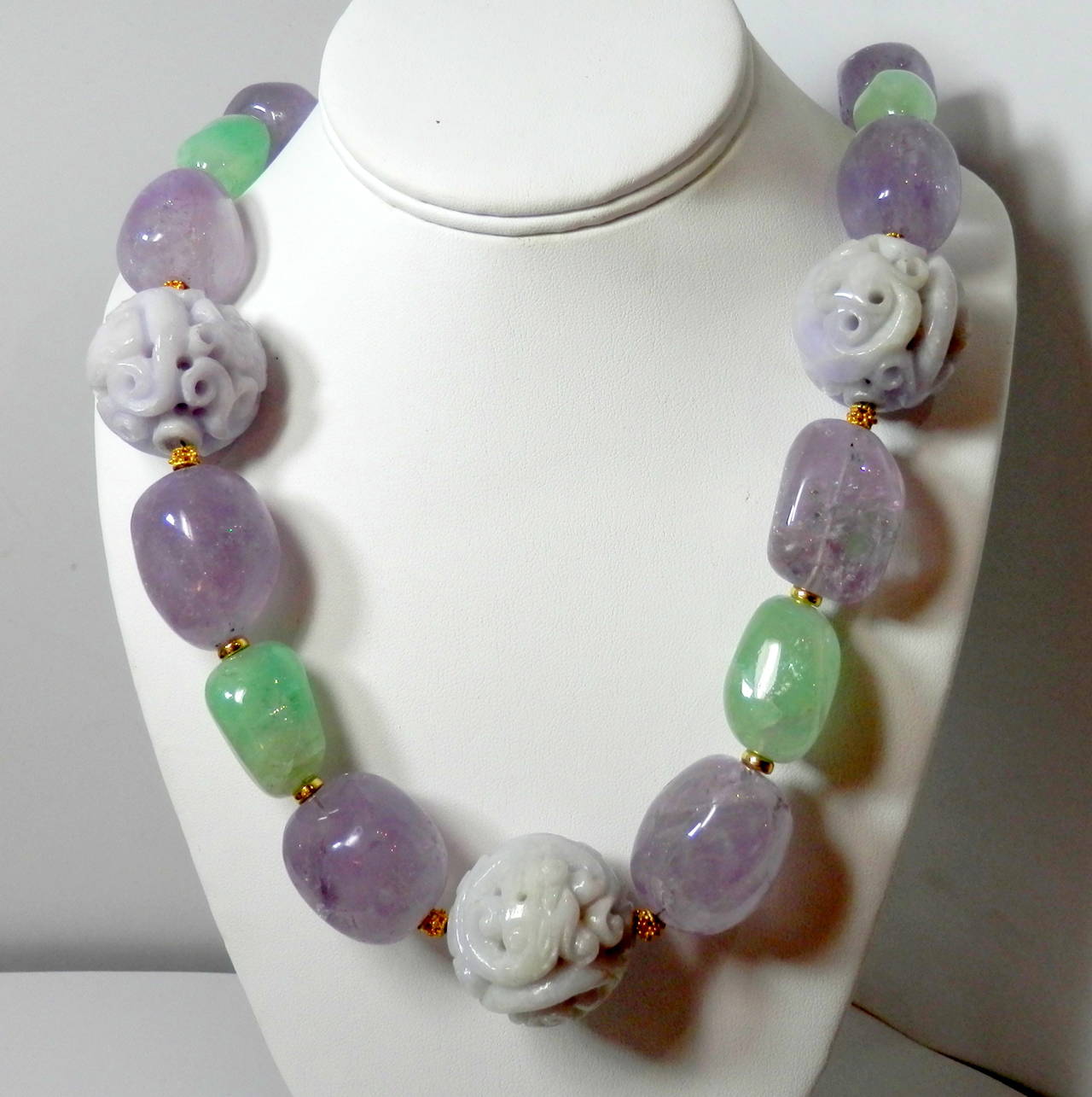 Several thousand carats of free form amethyst (medium to light lilac color, measuring approx. 20 to 23 mm.), emerald (light pastel green, measuring 18 to 22 mm approx.) and carved light lilac jade beads )measuring over 26 mm. in diameter.)