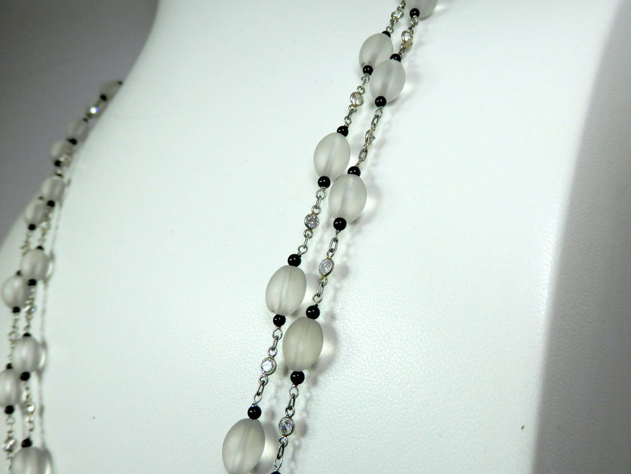 Small onyx beads are interspersed on either side on the rock crystal and these are separated by small full cut diamond brilliants spectacle set.  This chain can be worn long, double or tripled. 66 inches long