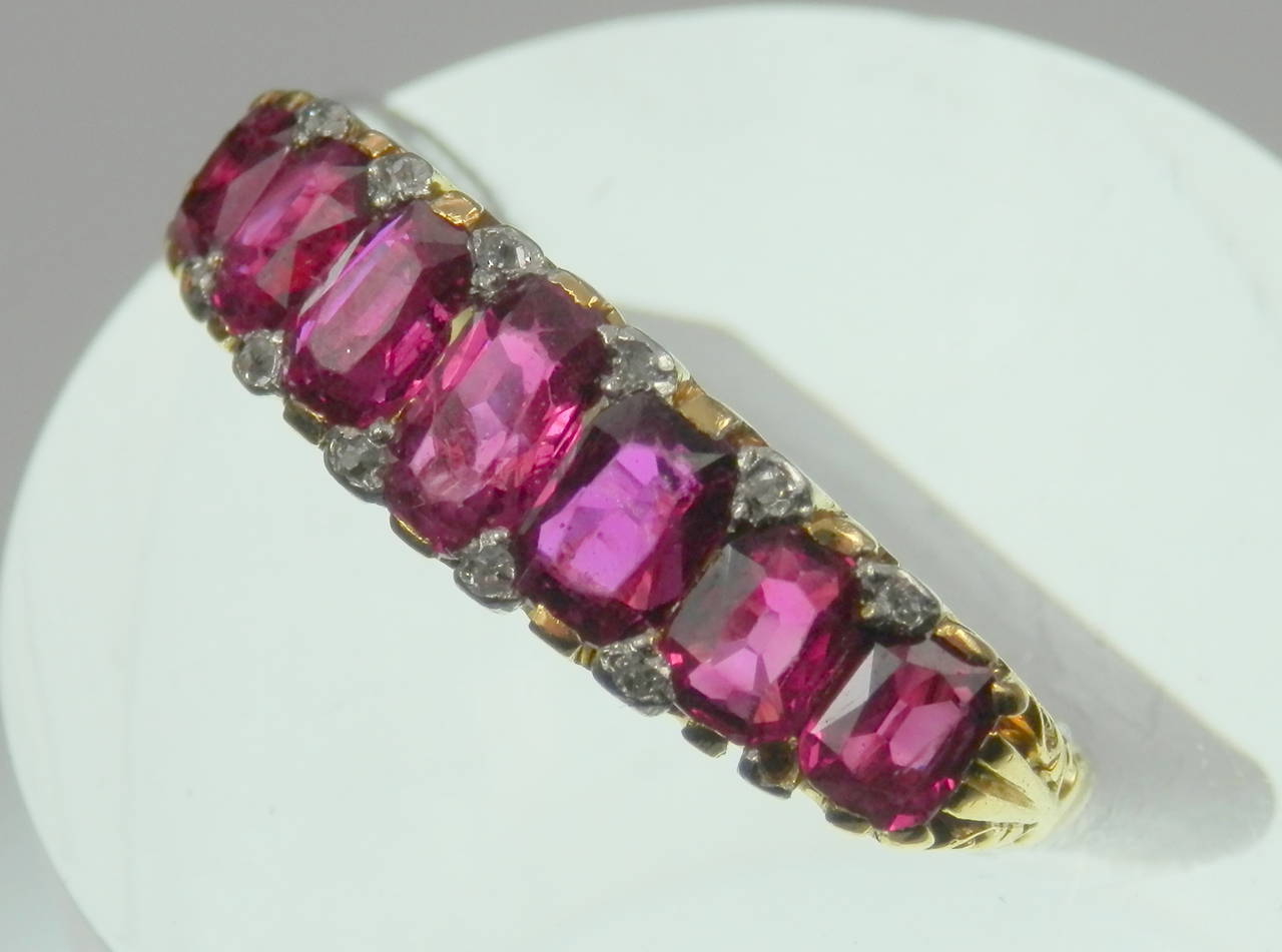 7 rubies cross the finger with approx. 4 cts. of natural Burma, no heat, ruby.  Tiny diamonds fill the interstices of each edge in an 18K.  This English heirloom is 1 inch wide and a quarter inch deep.  It is accompanied by a current AGL Report