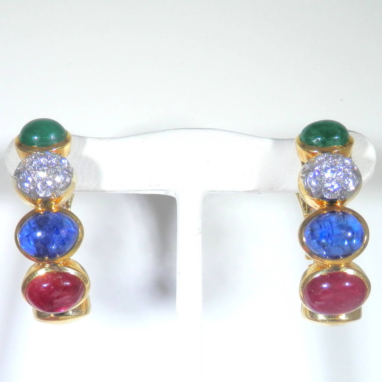 With 2 oval cab emeralds weighing approx. 2 cts., 2 oval cab sapphires weighing approx. 5 cts., 2 oval cab rubies weighing 6 cts., and 14 diamonds in a cluster weighing 1.20 cts., these earrings are 4 bright colors and are classic examples of David