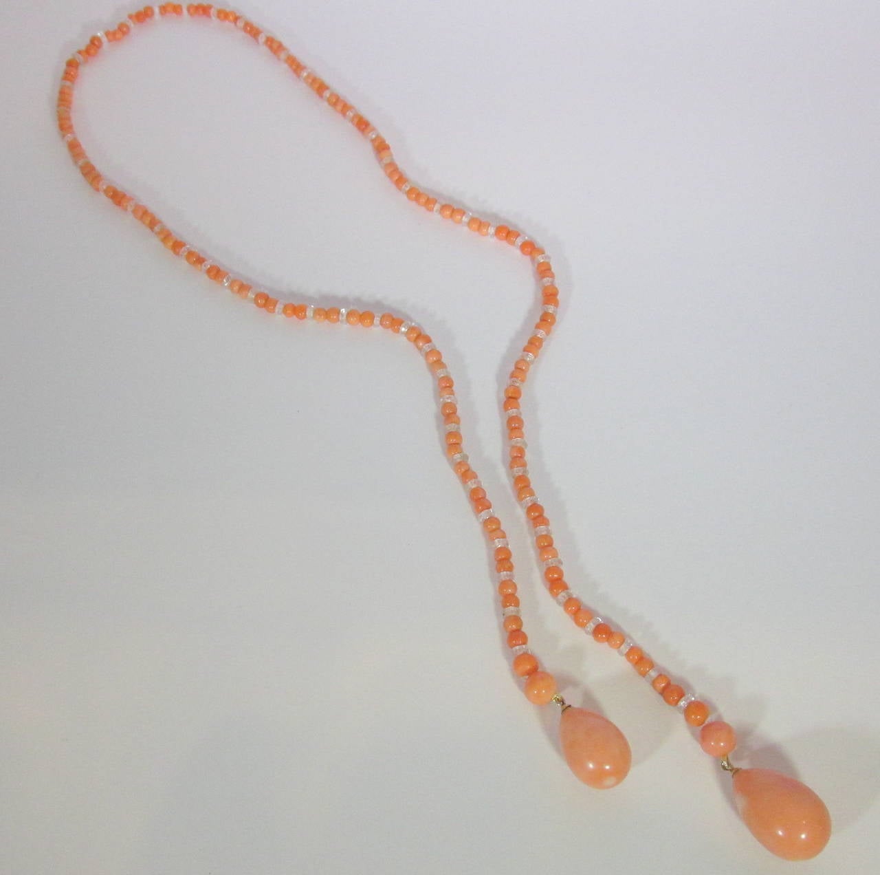 Untreated coral ( approx. 100 cts.) which is accented with faceted rock crystal 24.5 inches long sautoir terminating with pear shaped coral beads. The largest drop measures 20mm. by 13.5mm, and the smaller, 18 mm. by 12 mm.  This piece is worn by