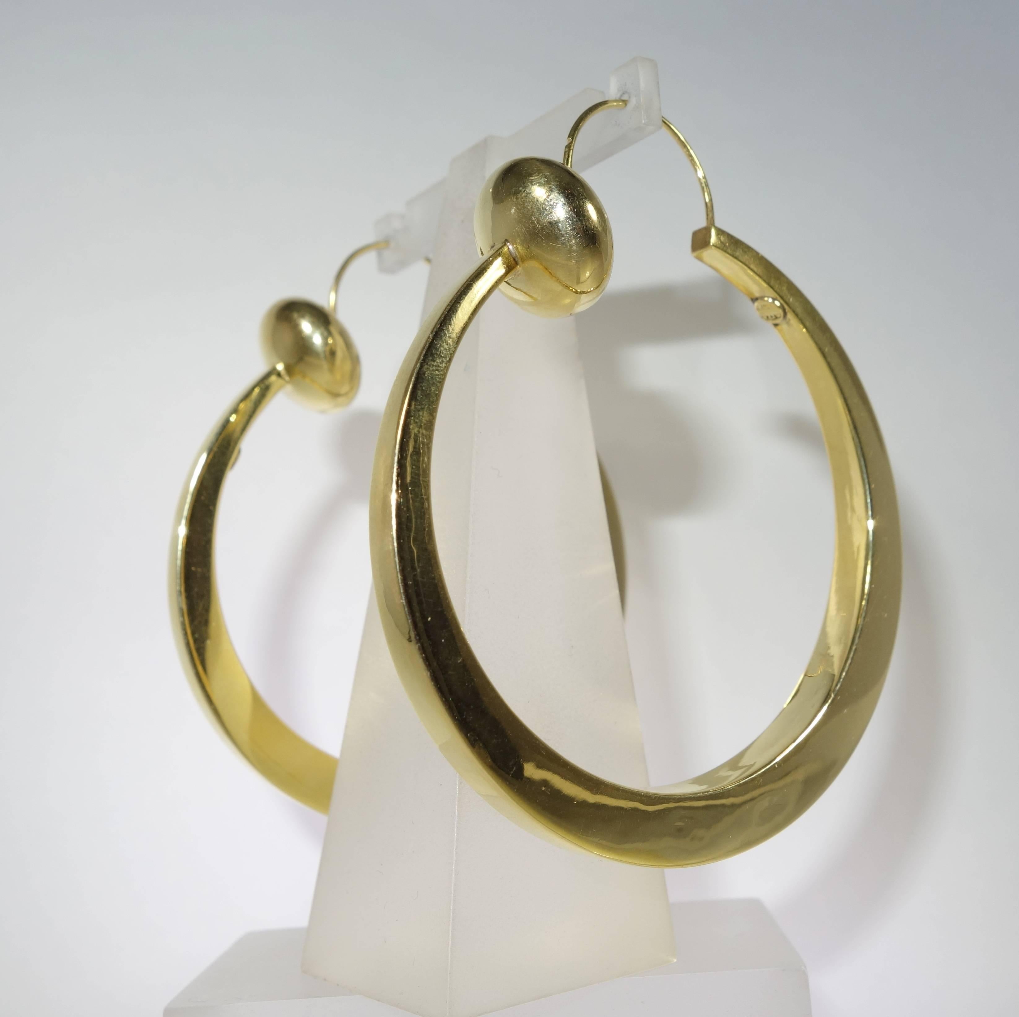 Women's Large stylized gold hoop earrings, c. 1950.