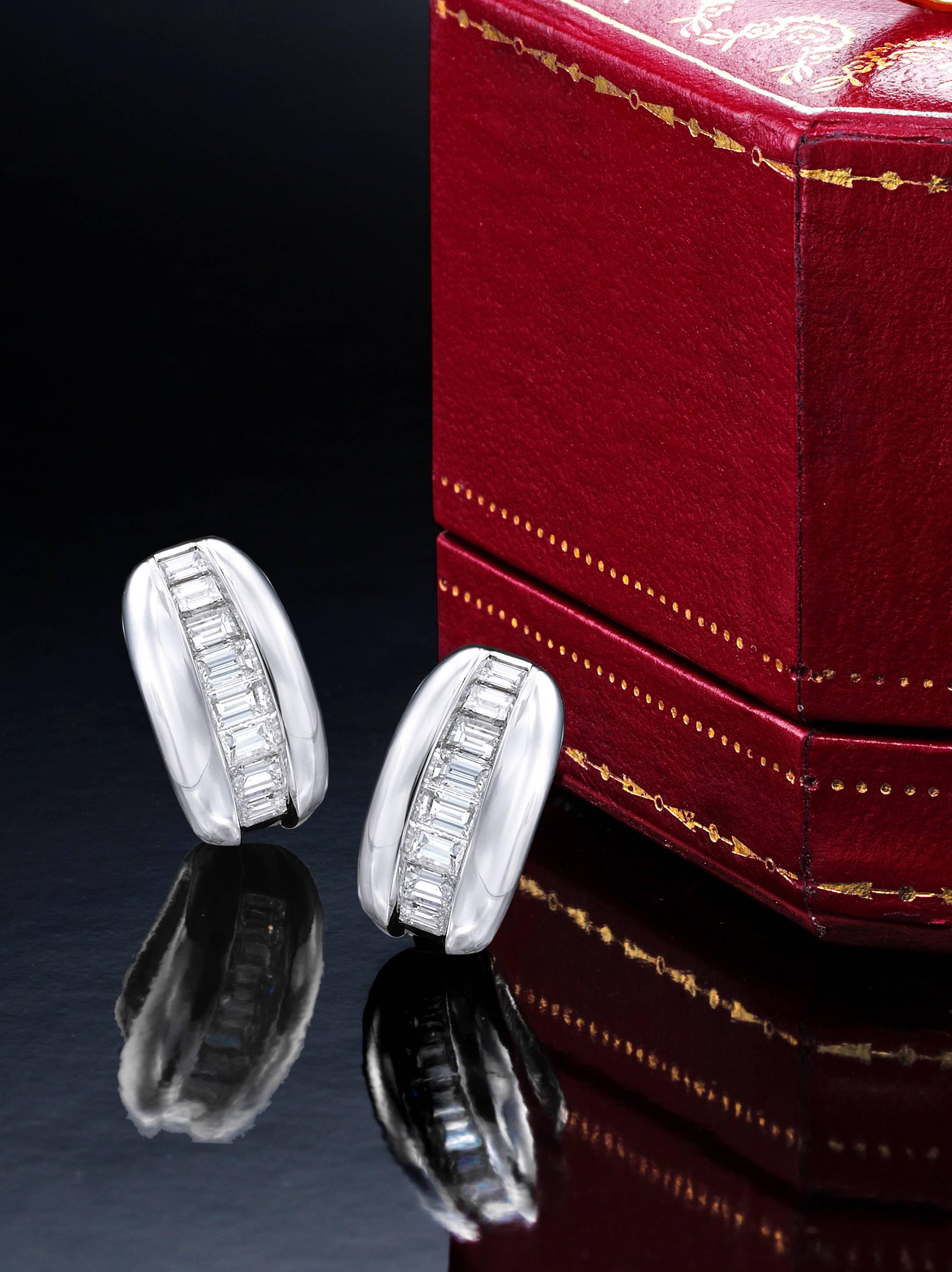 Sleek diamond ear clips by the world famous house of Cartier.   Made circa 1960, accompanied in their original fitted box, these earrings possess approximately 3.0 cts of fine white baguette cut diamonds.  These 18K earrings measure approximately