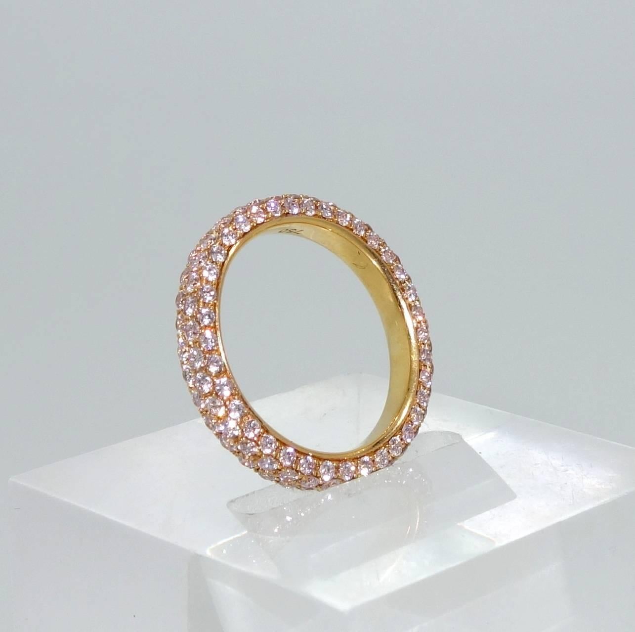 Well  match and finely cut light fancy natural pink diamonds are pave set in this pink gold band which is a size 6.5.  The four rows of light pink diamonds create a slight  domed paved surface of bright lively stones encircling the finger.  We will