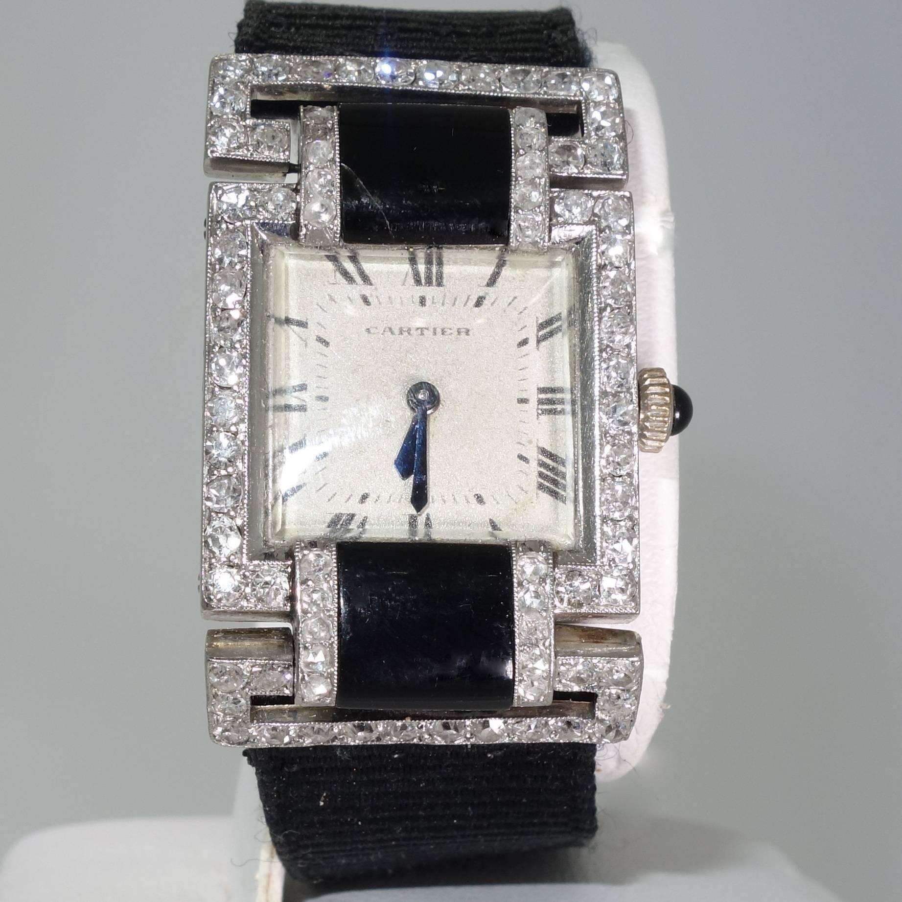 Fancy cut onyx, rose diamonds and European cut diamonds accent this lady's wristwatch by Cartier with a matching original diamond and onyx clasp which is a deployant type buckle. Sign by Cartier on the dial, and numbered on the verso as well as the