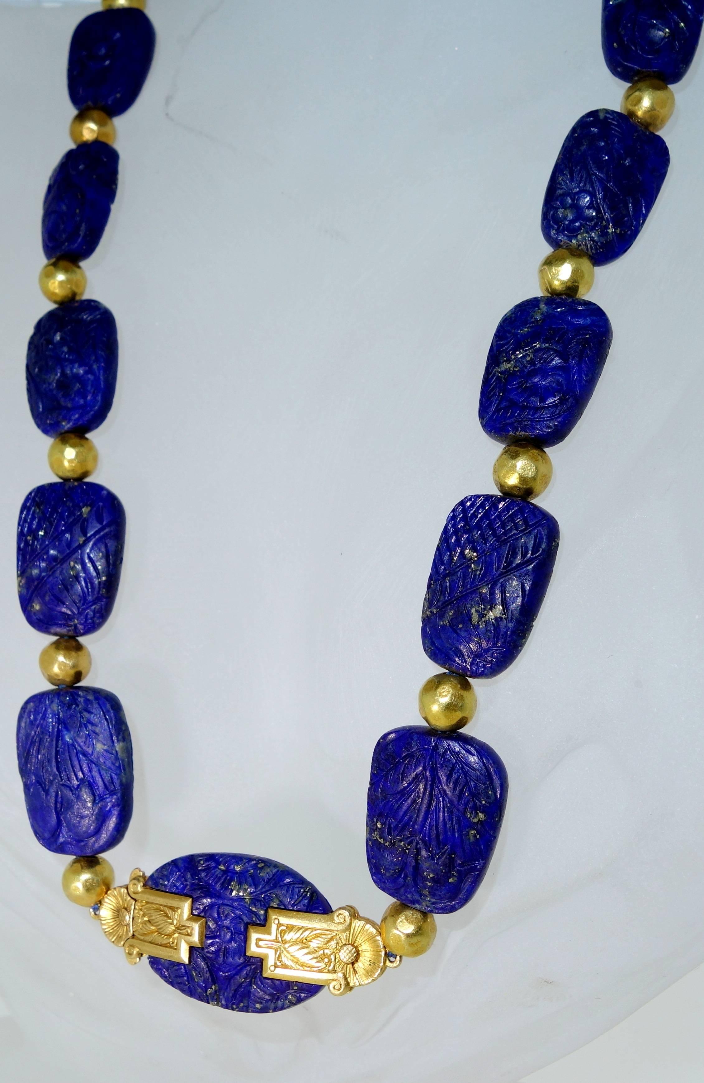 Seventeen finely carved - on both sides- lapis and interspersed with gold spheres that hand made and non-symetrical and terminating with an unusual finely carved gold clasp/center piece.  The lapis is a very bright blue with gold specks.  The