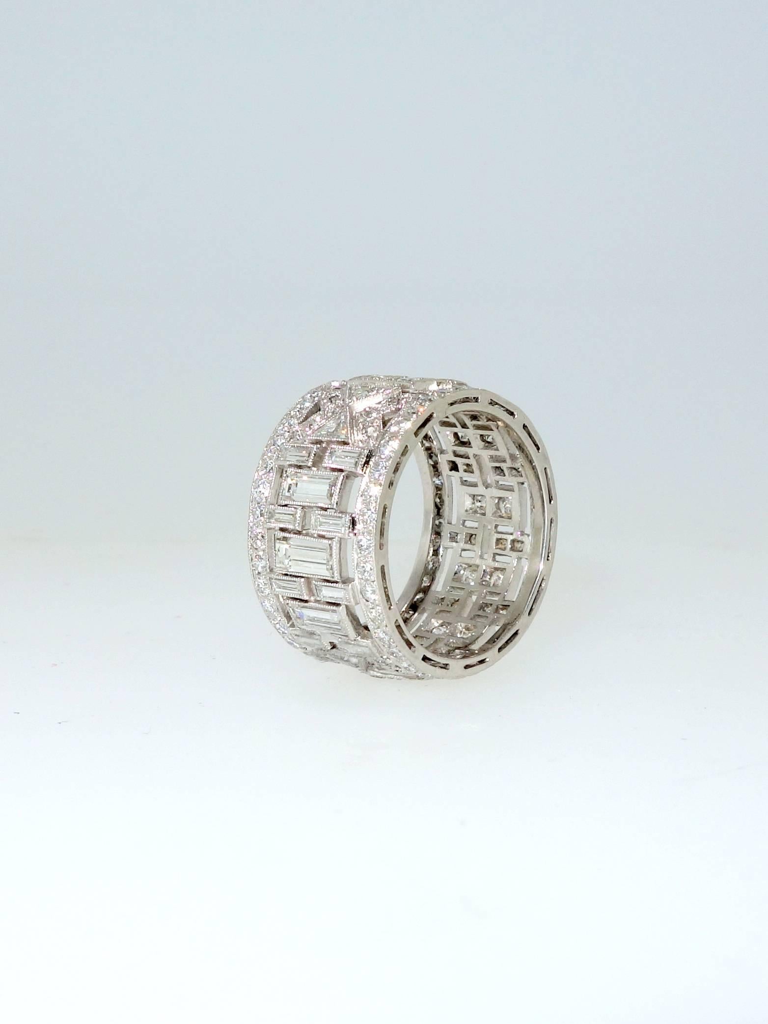 Set in platinum are round, baguette and triangular cut diamonds amounting to approximately 3.5 cts.  This band is a half inch wide and shows different rhythmic designs on each portion of the setting.  The diamonds are H/I in color (near colorless)