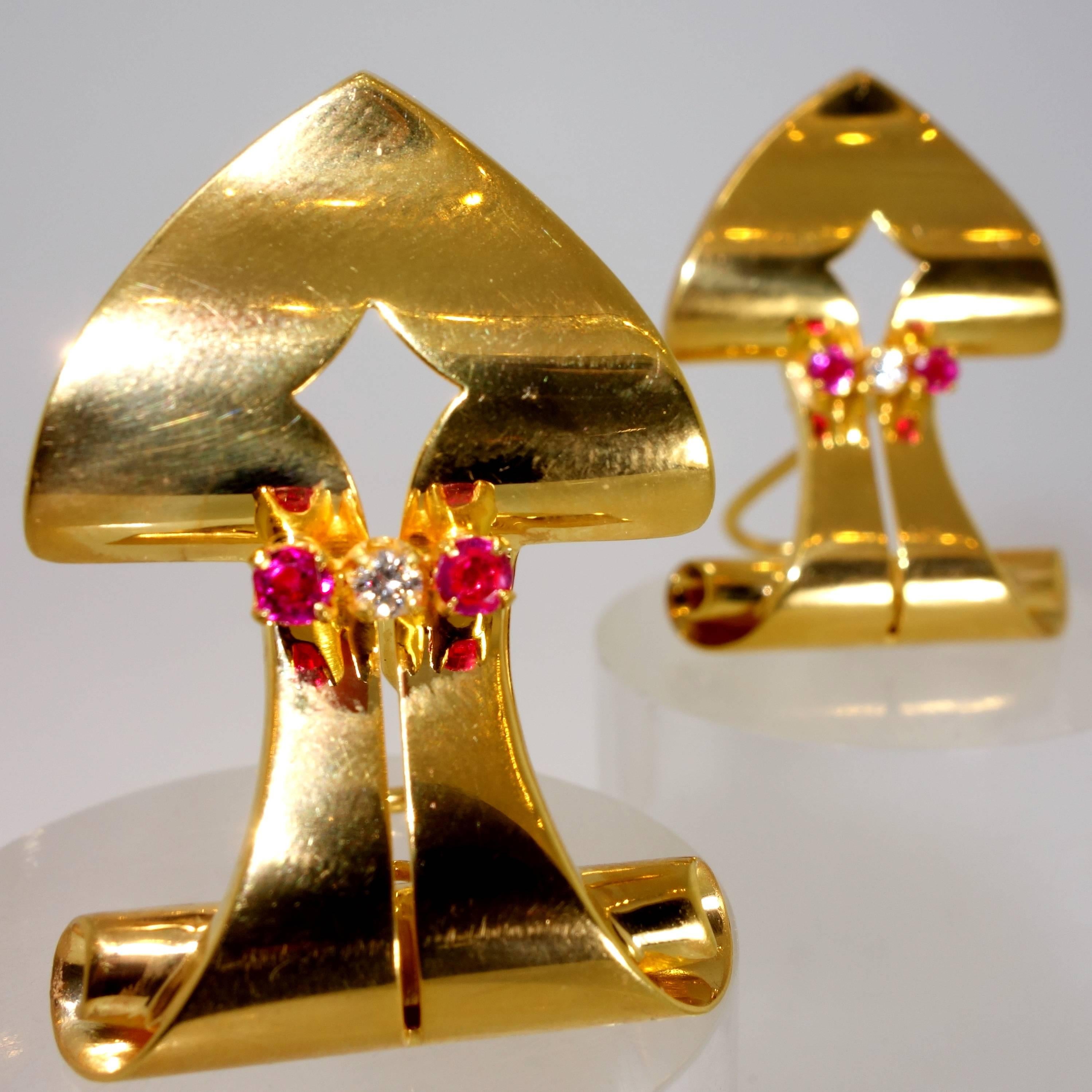 18K yellow gold in a shield shape with four natural rubies and two white diamonds  A classic retro or Art Moderne motif, one seen in brooches, clips and earrings, these can be worn either pierced or non pierced.  The two European cut diamonds total