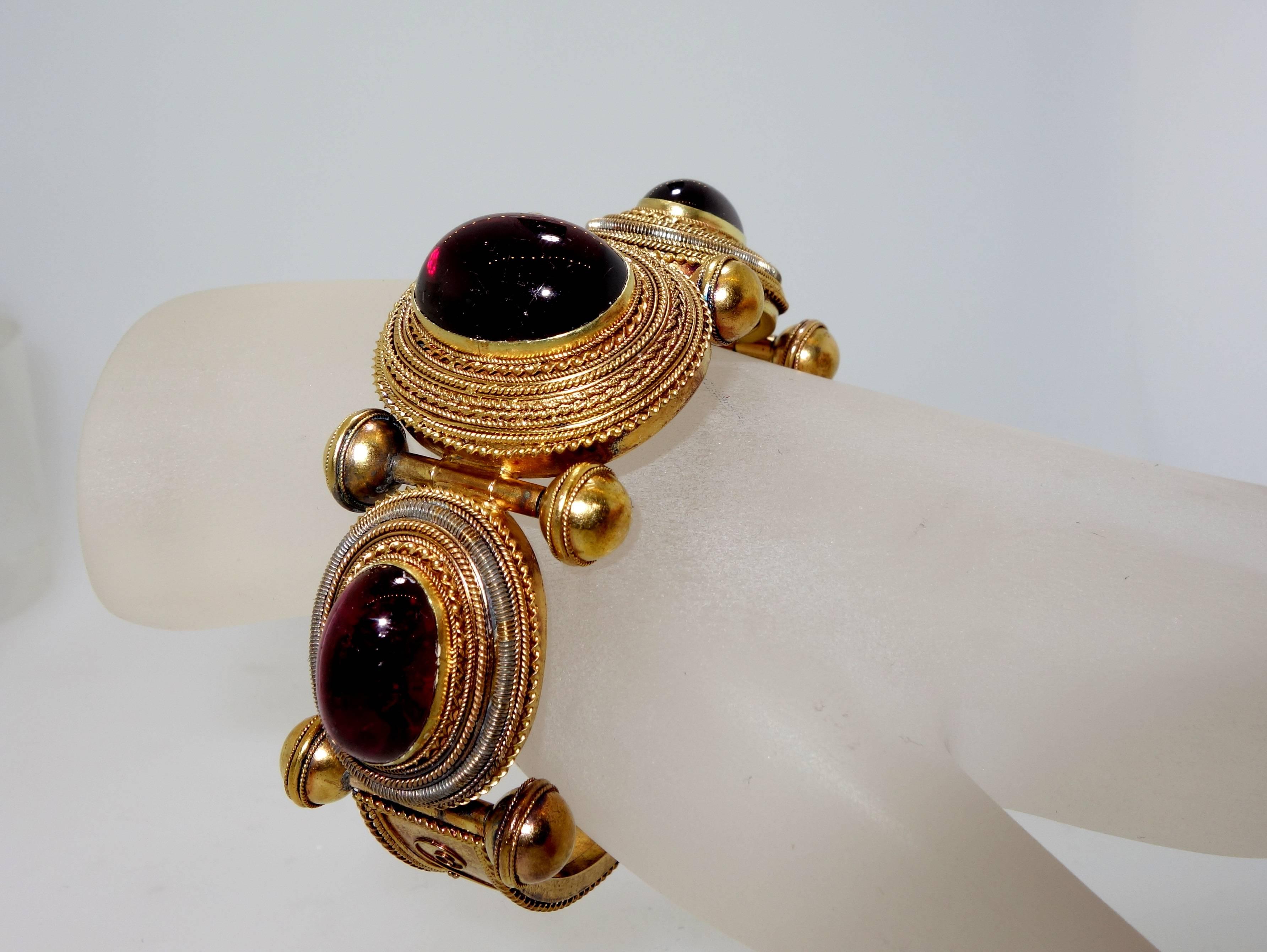 Fine Etruscan revival bead and wire work with three large cabochon cut deep bright red garnets (referred to as carbuncles).  This bracelet has an interior dimension of 2.25 inches.  While there are no marks, this piece is probably American, late
