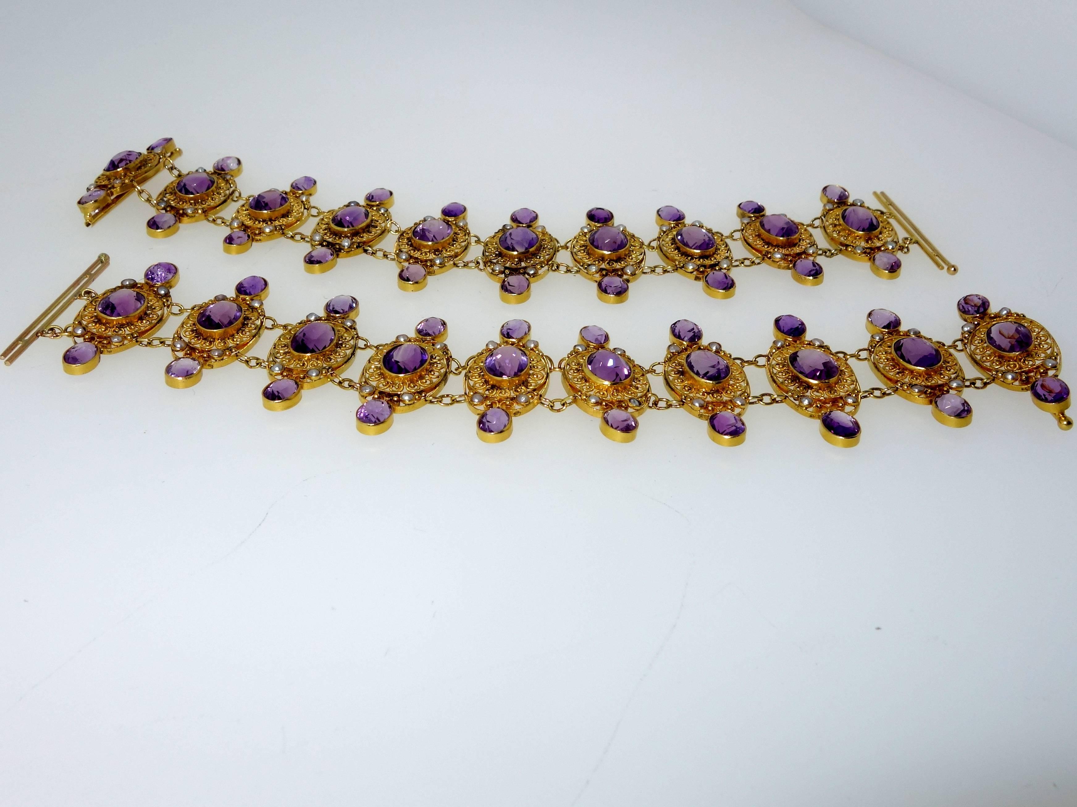 60 fine matched amethysts are set in gold and accented with small natural oriental pearls.  This pair of bracelets, both seven inches in length, can be worn together or on either wrist.  Clasped together and they form a necklace.  Victorian, circa