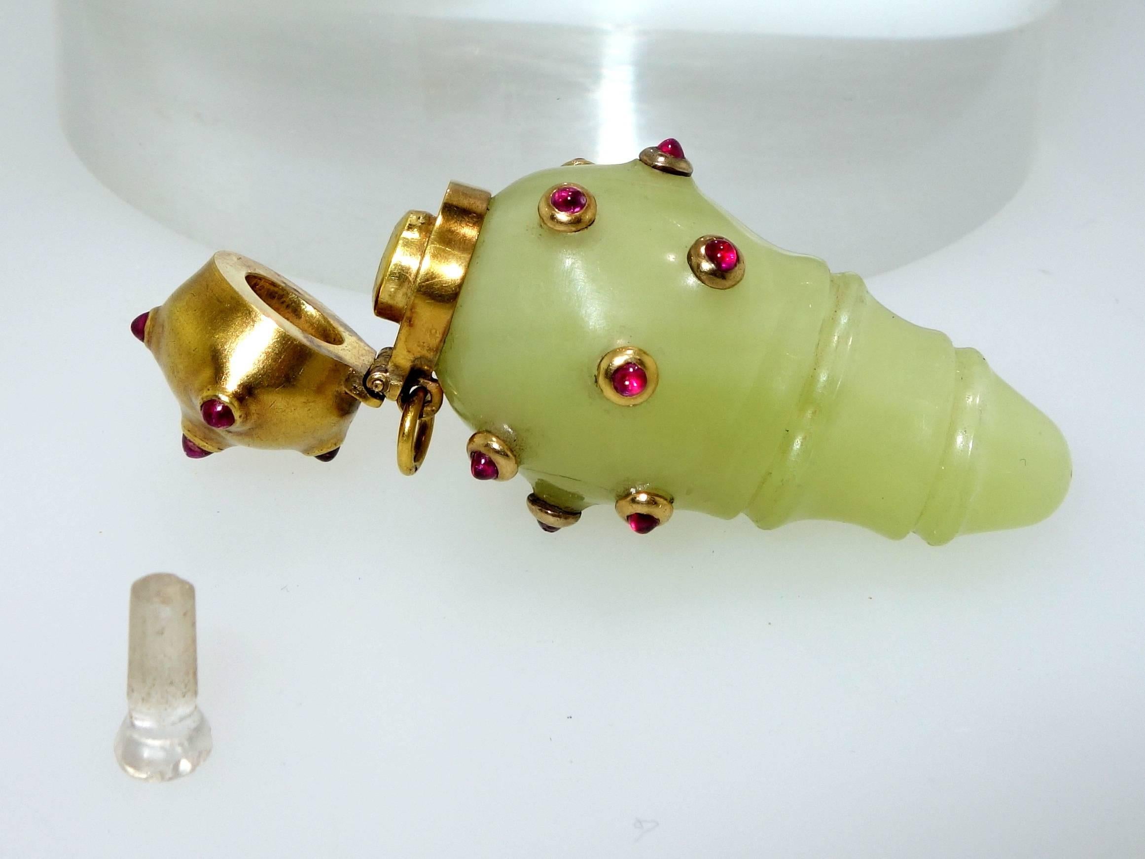 This scent bottle is 18K gold with 17 natural unheated Burma rubies.  The carved stone is Bowenite which is an unusual hard stone.  This piece bears European hallmarks.   This piece can be worn on a chain or can be a vanity room accessory.  It