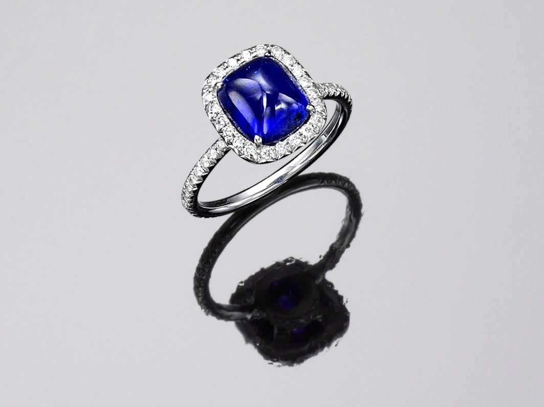 The high sugarloaf unheated natural (certified) vivid pure blue sapphire weighs  3.47 cts.  It is surrounded by fine white well matched modern diamonds all (G/H) and very slightly to very very slightly included (VS/VVS).  This ring also has matching