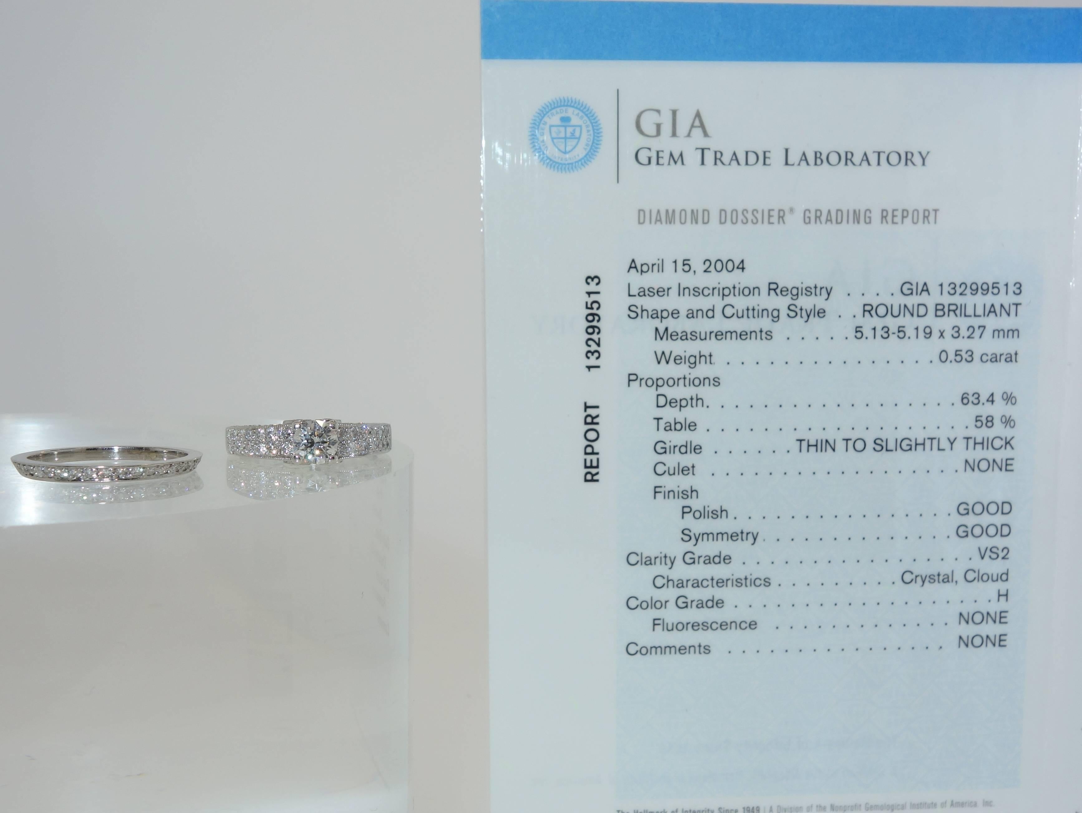 The center round modern brilliant cut diamond has been examined by the G.I.A. and weighing .53 cts, H/VS2, no fluorescence and no comments.  This diamond is accented by 52 matching diamonds weighing approximately .66 cts.  This ring is accompanied