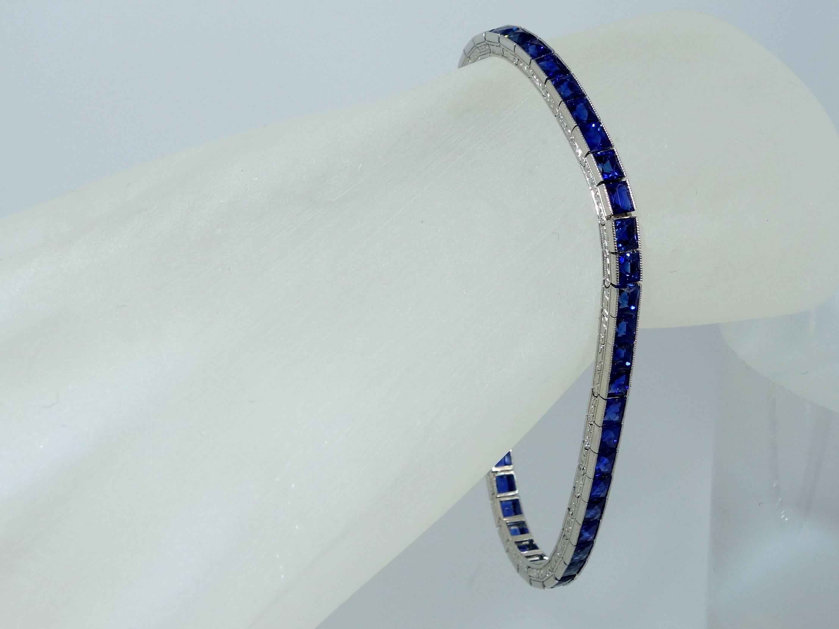Made by Oscar Heyman and numbered this platinum bracelet with engraved edges possesses 50 fine French cut sapphires displaying a clear bright vivid blue color, and, in our opinion, probably Burma and unheated.  There are approximately 15 cts. of 