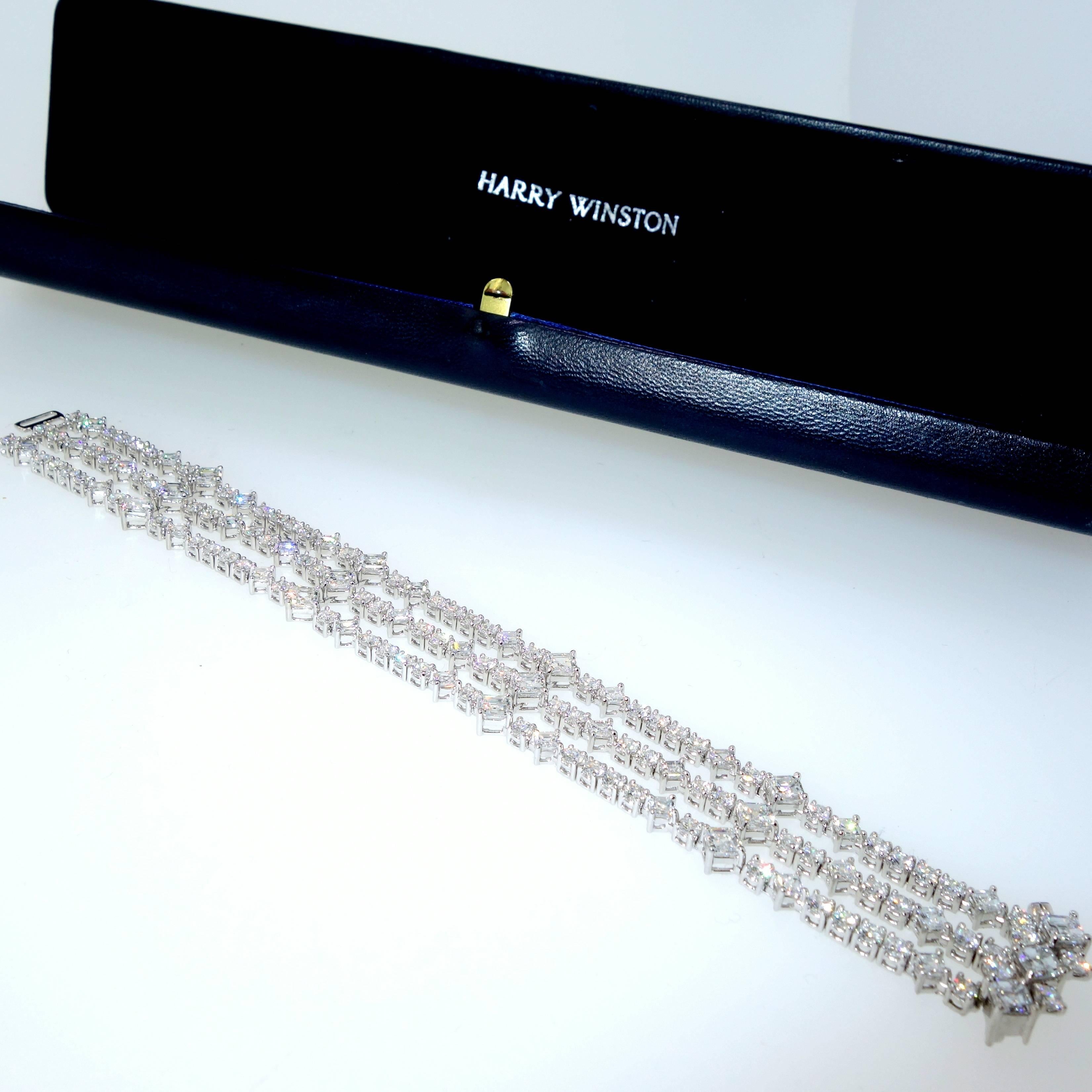 This articulated platinum bracelet, by Harry Winston, stock number 107672, of open work design comprising three rows of square emerald cut emeralds and round brilliant cut diamonds intersected by four rows of square emerald cut diamonds.    There