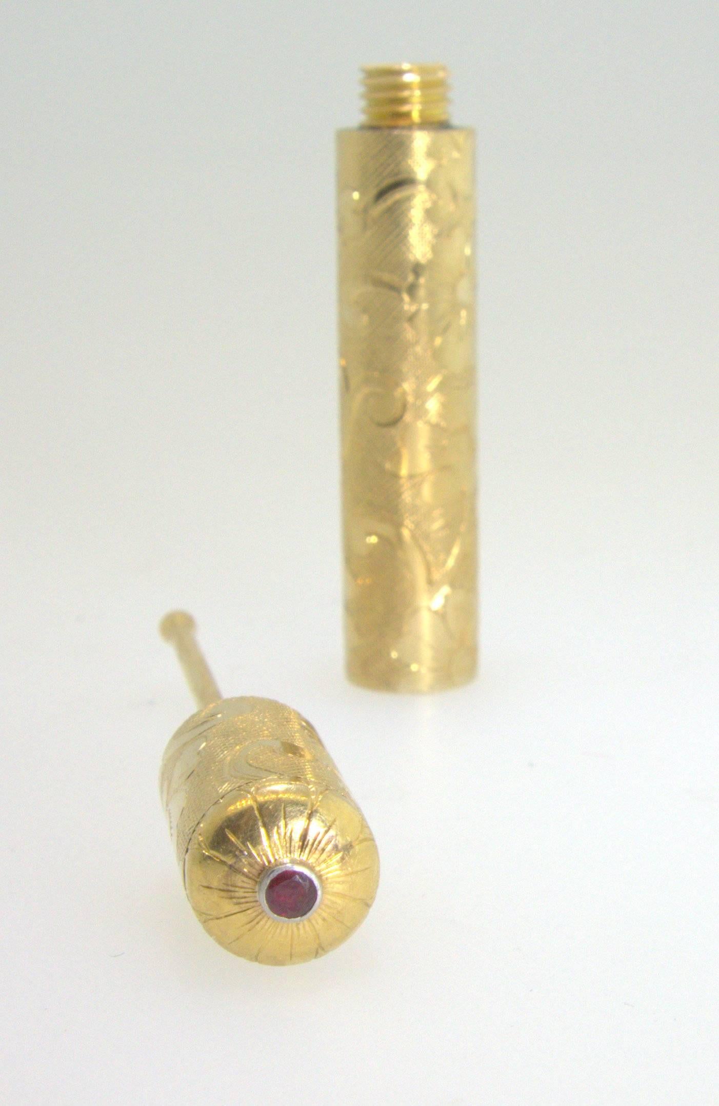 Circa 1950,  18K yellow gold finished with a small ruby, this perfume holder for the purse was made by the great house of Van Cleef & Arpel, France.  It is signed and numbered.  It measures over 3 inches long.