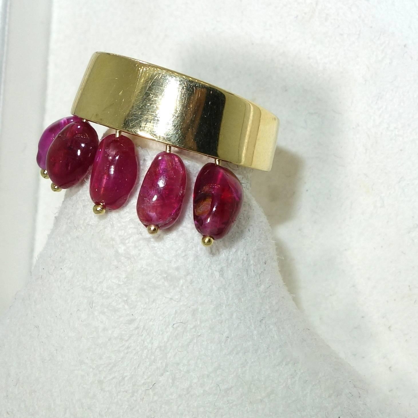This unusual ring has five drop natural bright rubies suspended from the 18K ring.  There are approximately 4 cts. of rubies.  The ring is a size 6 and can be sized.   On the interior of the shank the ring is stamped 750 with other marks from the