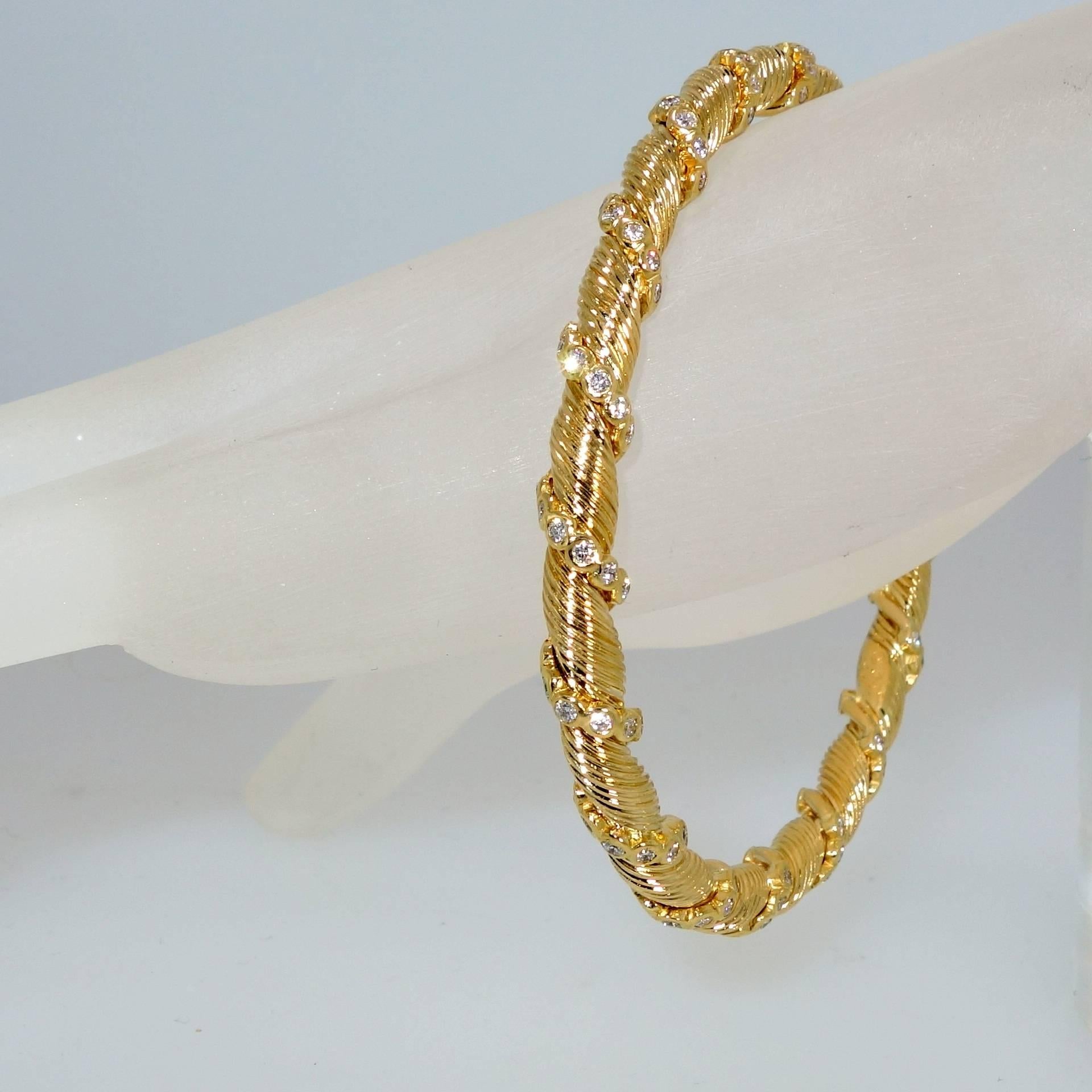18K yellow gold bangle with 126 round diamonds with an approximately 3.0 cts. of fine white diamonds.  The bangle has an interior measures 2.5 by 2.25 inches and as an oval shape the interior circumference is 7.5 inches.  The weight is 26.18 grams.