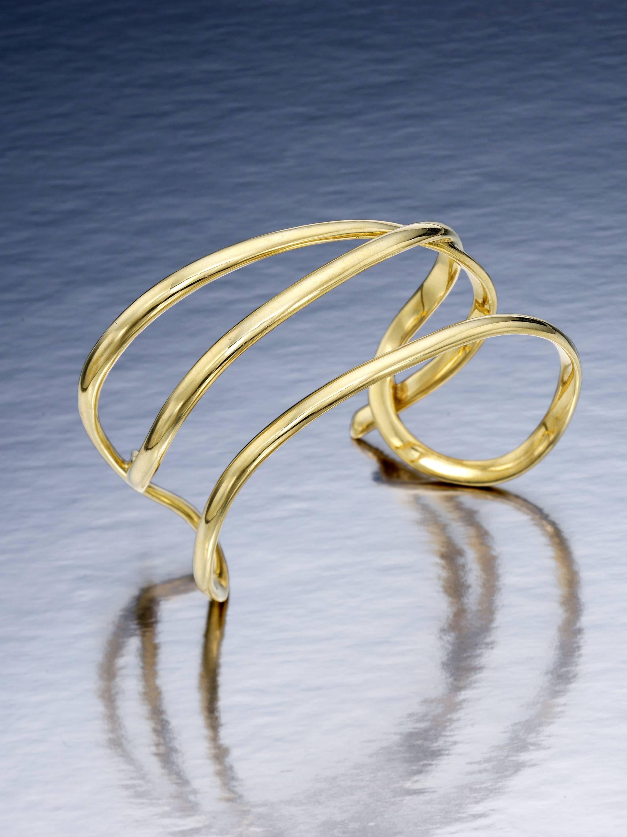 18K polished yellow gold bracelet by Tiffany & Co.  It slips on easily and will fit most wrists.  It is a large size, but it can be fitted to a smaller wrist  It is 1.25 inches wide and 56.4 grams.  