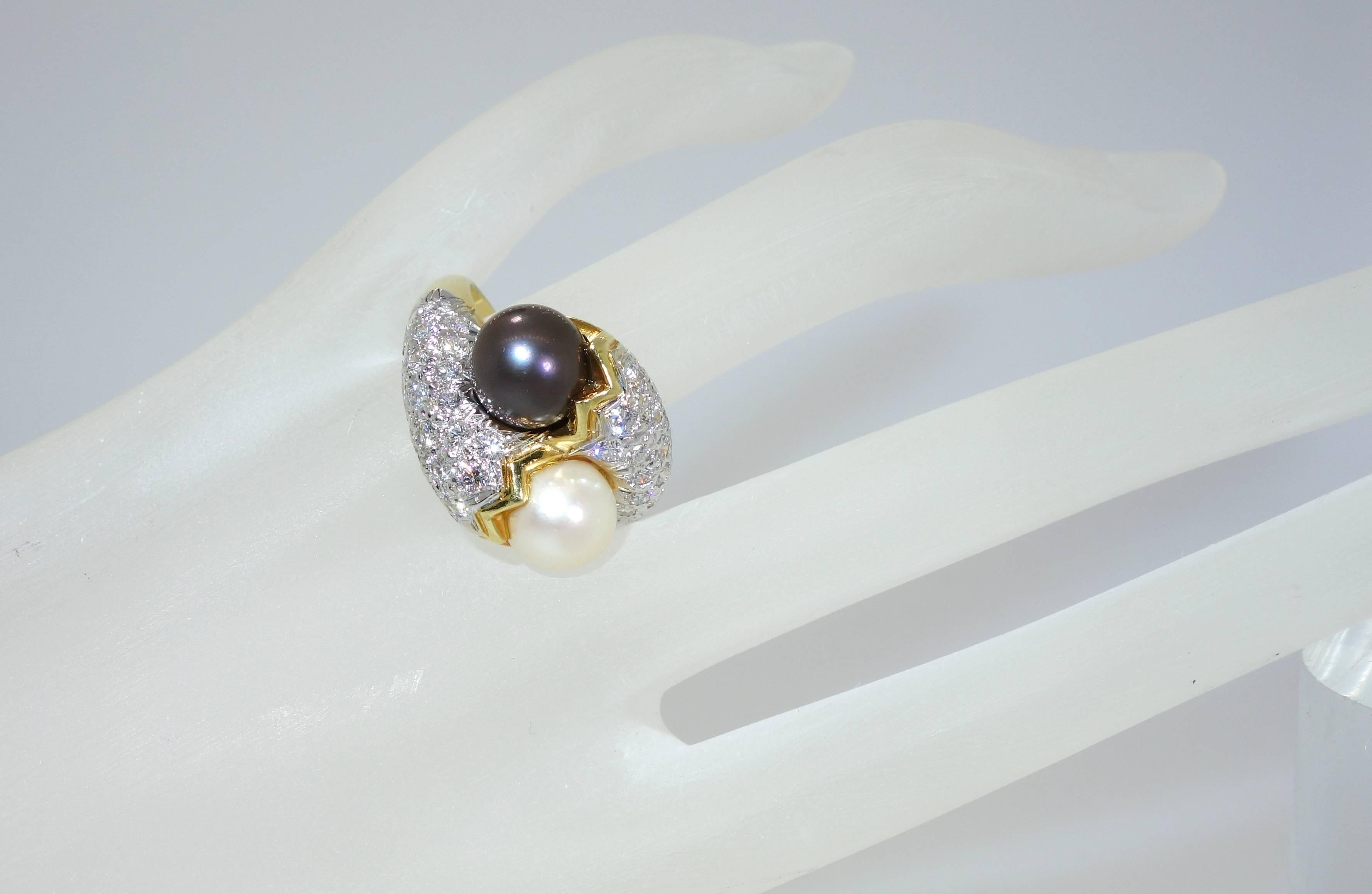 18K yellow gold possessing two fine pearls - black and white with 42 fine white diamonds which total approximately 1.25 cts.  These diamonds are all well cut, white and bright.  The ring is numbered 30353, unfortunately the name has been polished
