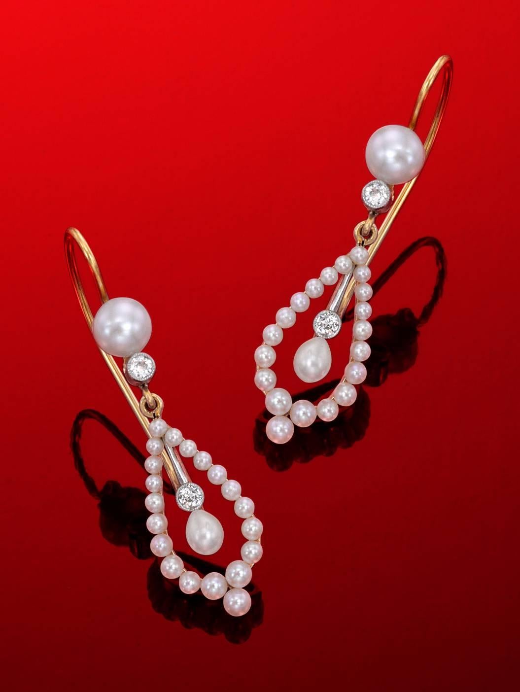 44 natural oriental pearls are accented by 4 European cut diamonds, (totaling .12 pts.) which are set in milgrained platinum bezels.  These sublime little beauties are approximately 1.25 inches long.  They bear no gold content  marks, which was not