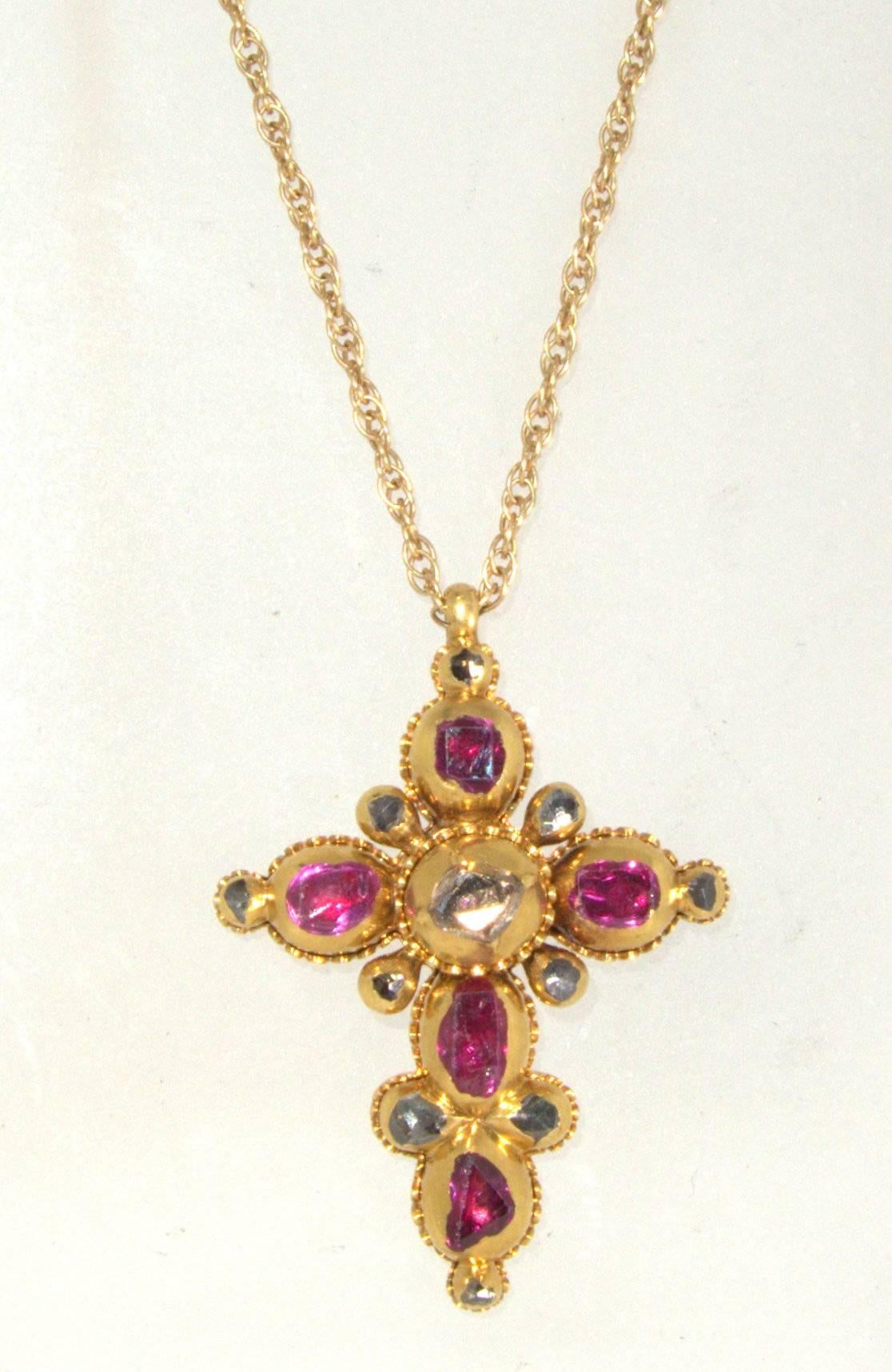 Very early table and rose cut diamonds and rubies are set in closed back 18K gold.  This cross is in fine condition especially when one considers its age.  The cross is 1 1/3 inches long and is suspended on a newer 14K chain.  Finished with  a