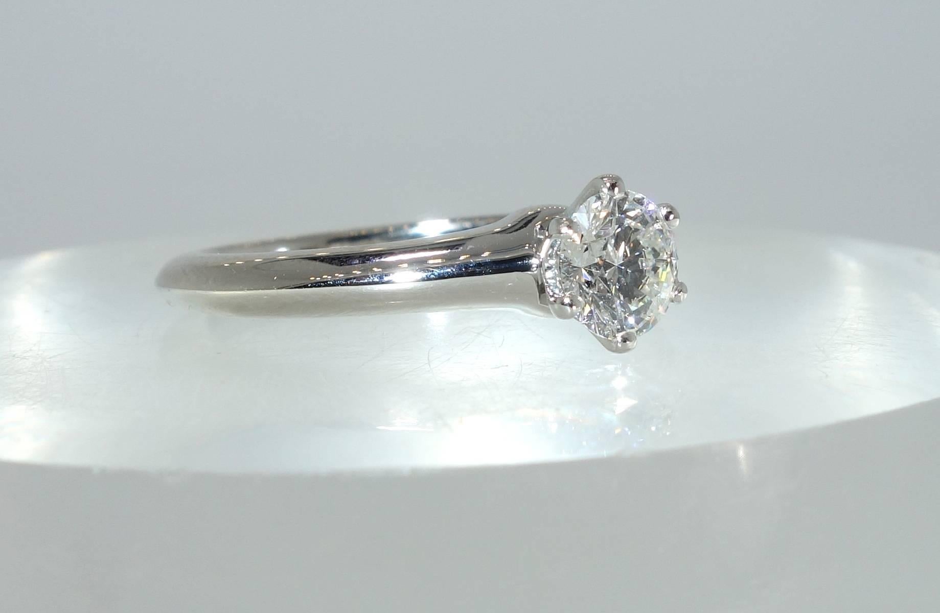 The center modern round brilliant cut diamond weighs .54 cts. and is near colorless (G), and VS (very slightly included).  This fine white diamond is prong set in a fine platinum mounting by Tiffany & Co.
