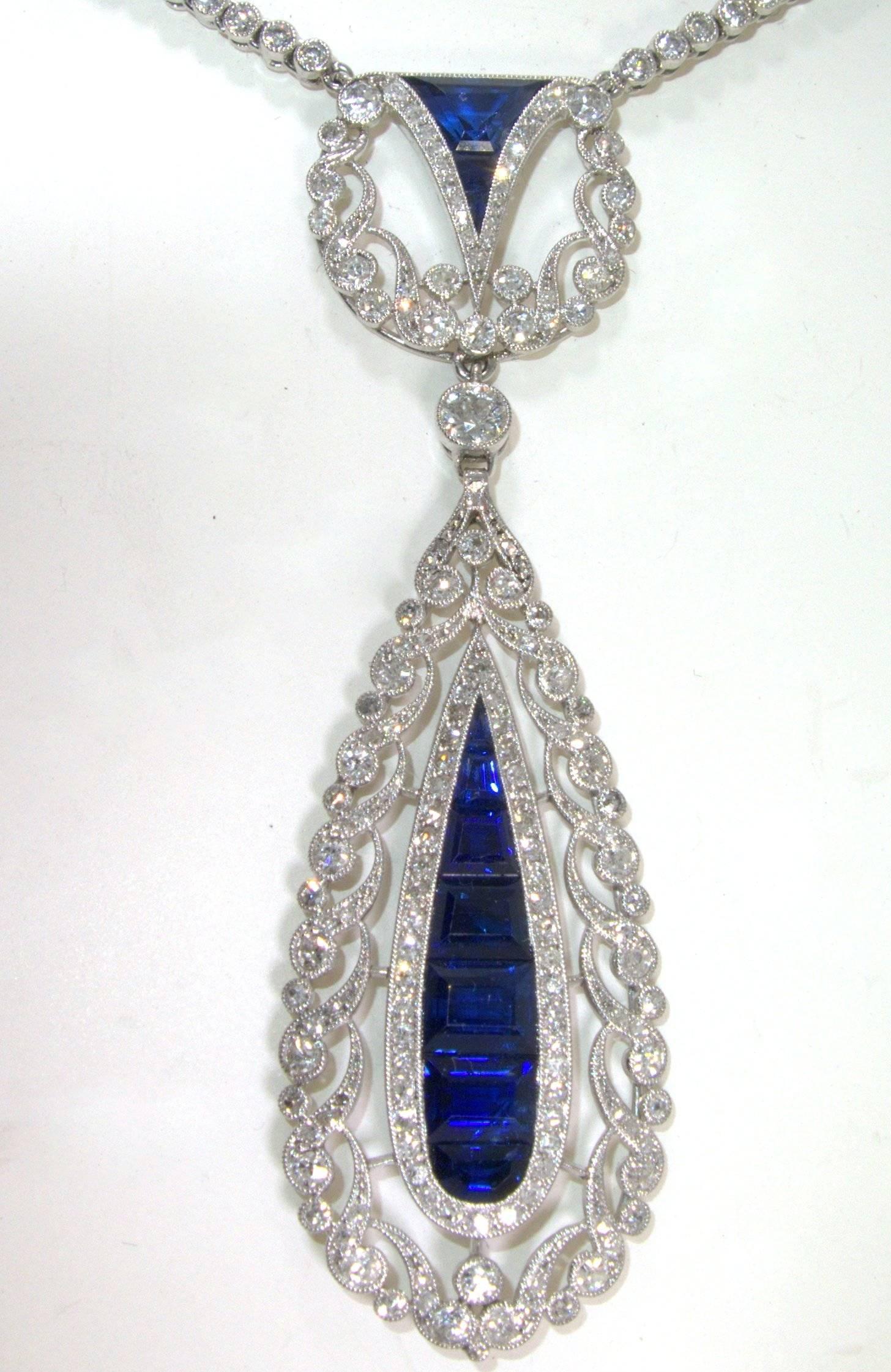 Over 300 diamonds are set in this striking Art Deco pendant necklace with 10 fancy cut natural bright vivid natural blue sapphires which are surrounded by fine white European cut diamonds and rose cut diamonds. The well made Art Deco pendant is