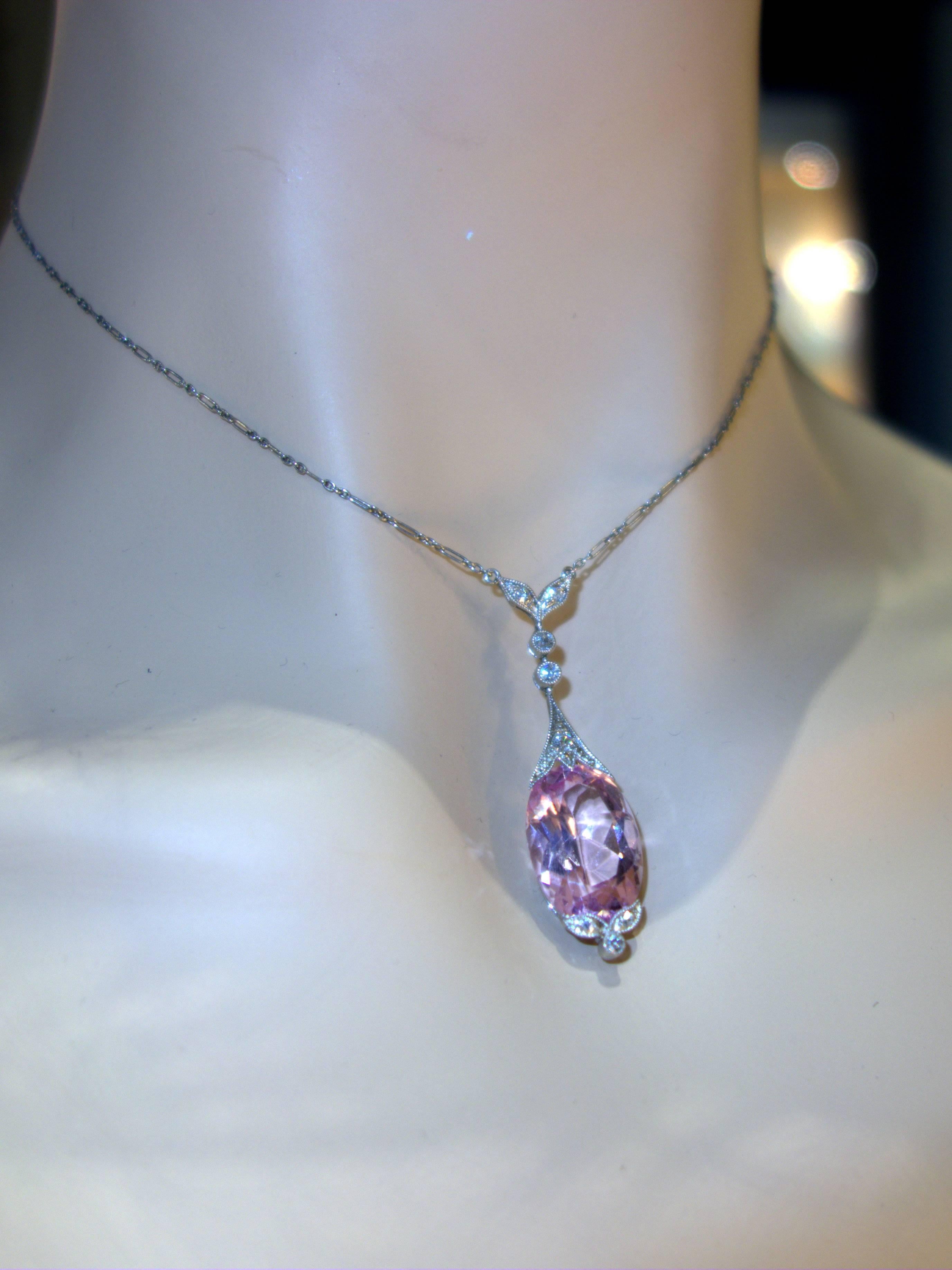 Delicate and feminine, this drop necklace has diamonds set in miligrained bezels with a suspended fine bright pink morganite.  This natural stone weighs approximately 12 cts.  This pendant was made circa 1918.