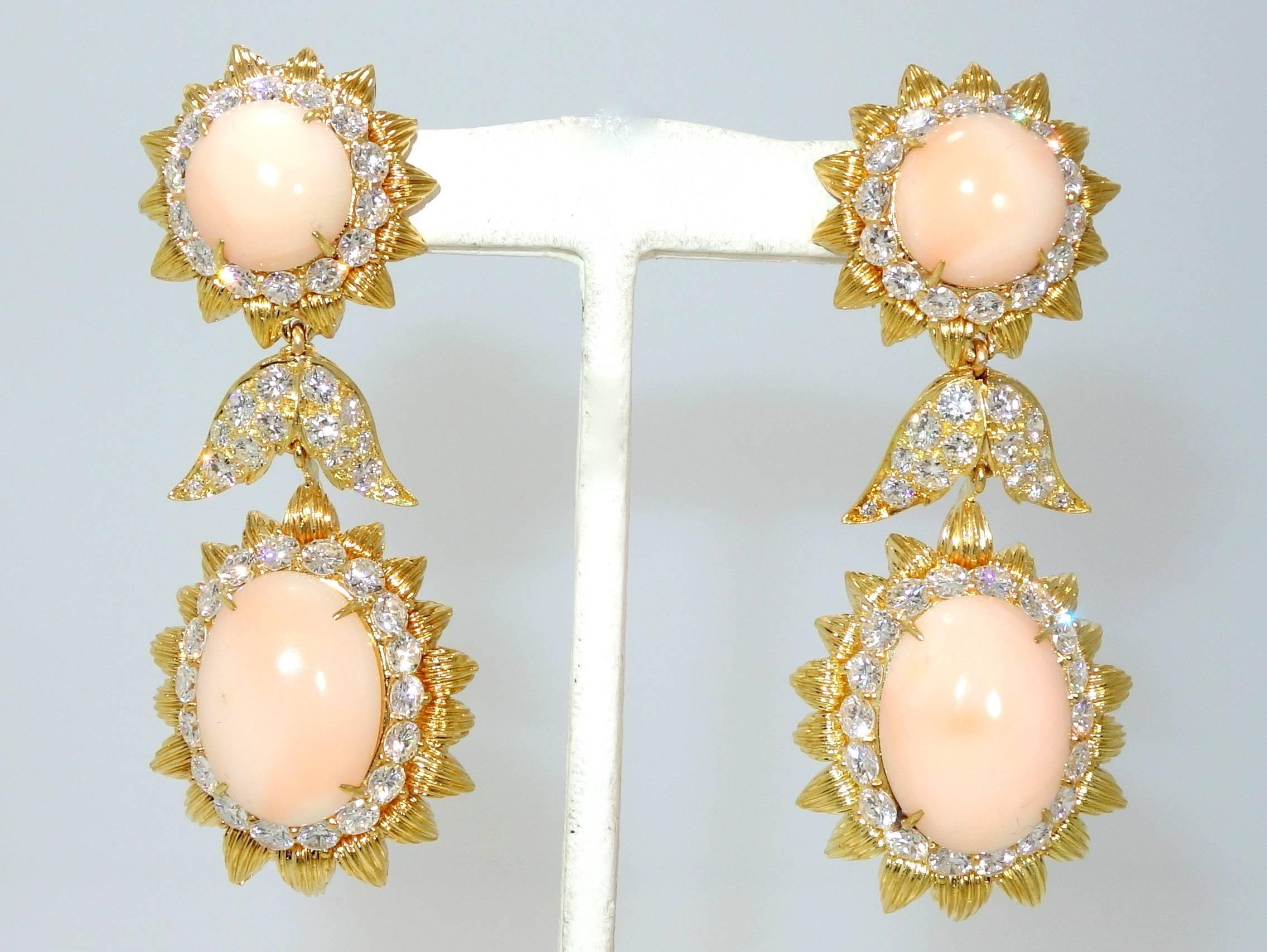 Circa 1960 with 92 fine white round diamonds weighing approximately 10 cts., accenting the center angle skin coral, these 18K earrings are a dramatic - over 2.5 inches long - and classic statement for the ear.
