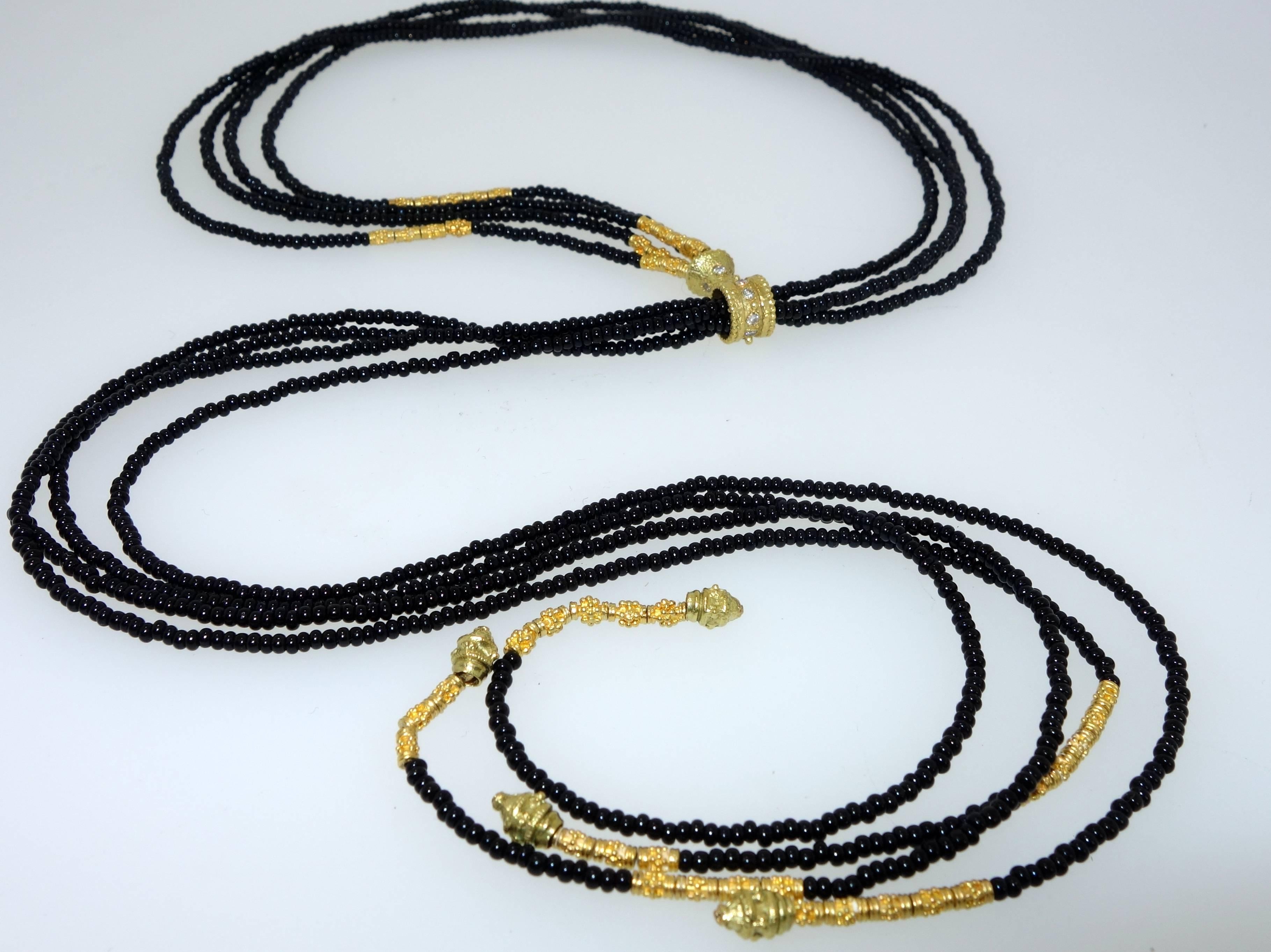 14 small diamonds adorn this unusual necklace.  The four strands of onyx beads terminate with hand made gold elements.  The gold sliding clasp in the center can be adjusted and worn closer around the neck or looser depending on the wearer's wish. 