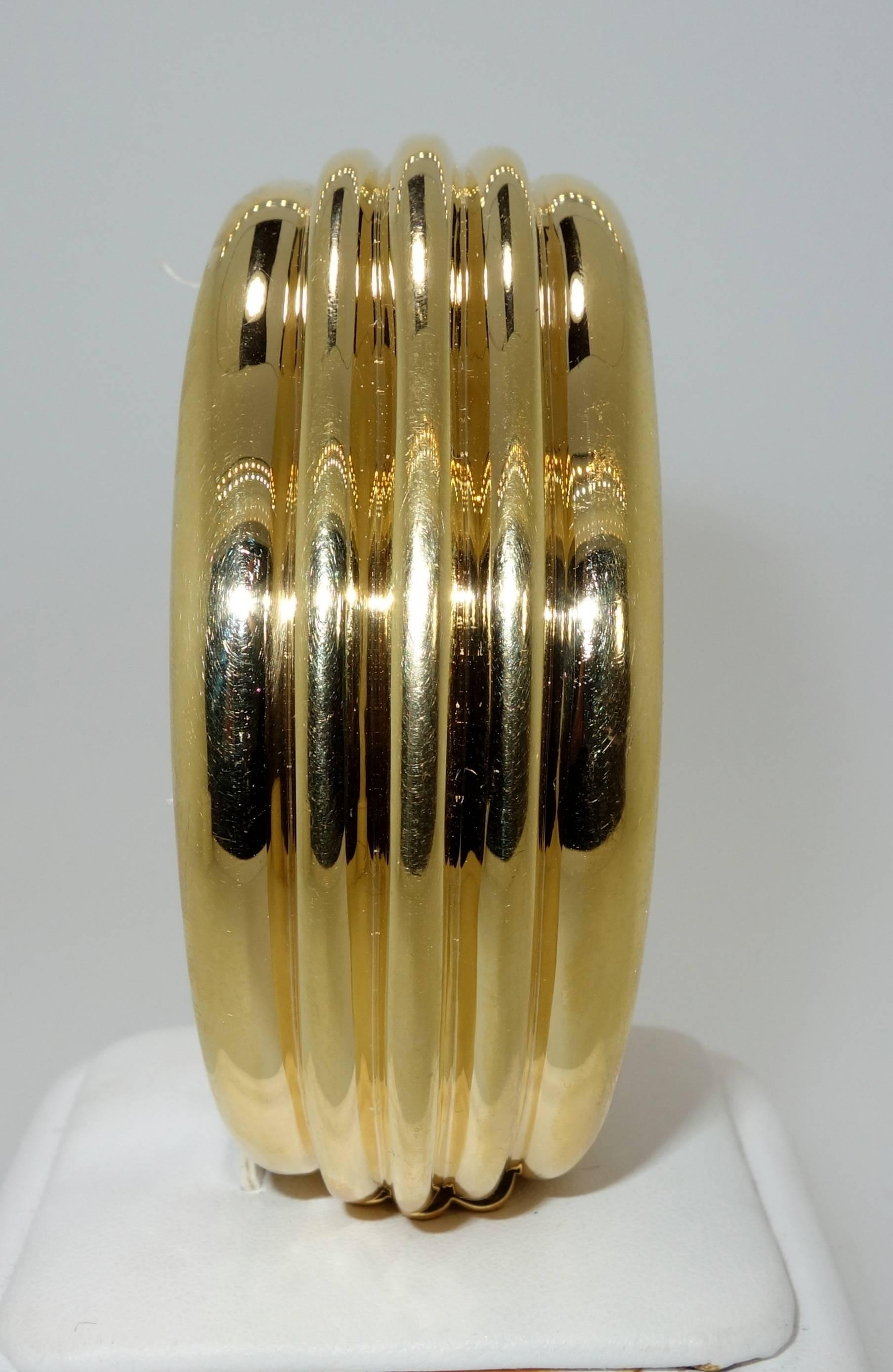 18K yellow gold bangle bracelet weighing over 126 grams.  Interior circumference is 6.75 inches.  This bold  and unusual statement for the wrist is sightly less than 1.25 inches wide.  Signed Cartier and numbered.  All of our pieces arrive in a fine
