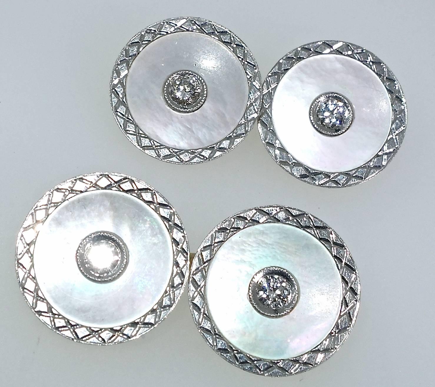 Platinum cufflinks with engraved edges surrounding white mother of pearl  and a bead set diamond in the center and backed with gold.  There are .33 cts. total weight of the white European cut diamonds.  Early Art Deco and in fine condition. 