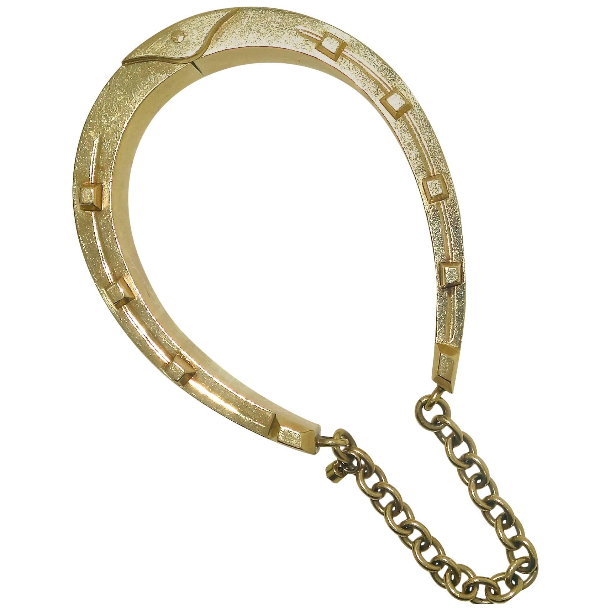 Unusual in design, this gold bangle bracelet opens up wide so that the wrist slips on with ease.  It is an unusual sporting motif design of a classic horse shoe.  A similar  bangle bracelet can be seen in the book, Nineteenth Century Jewelry by