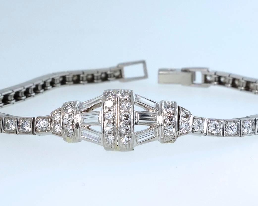 Tiffany & Co., and signed on the clasp, this platinum, petite, diamond bracelet has 6 baguette cut diamonds in the center geometric element with round brilliant cut diamonds continuing down the sides of the bracelet.  There are approximately 2.75