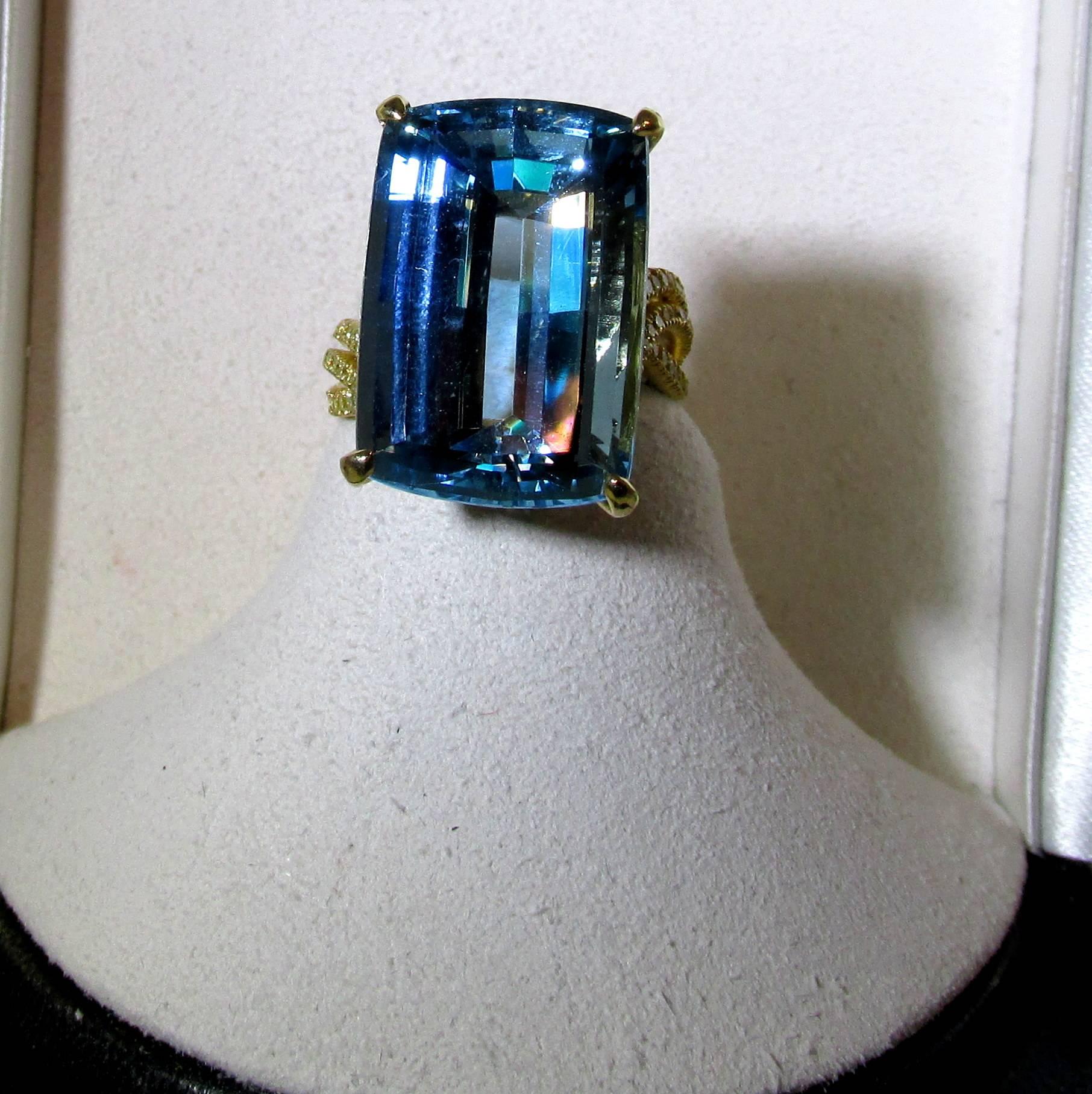 18k unusual asymmetrical hand made ring micro pave set with 195 small round natural fancy intense diamonds  weighing approx. 1 ct.,and possessing a center fine natural bright blue aquamarine.  The aquamarine displays an even blue color with no green