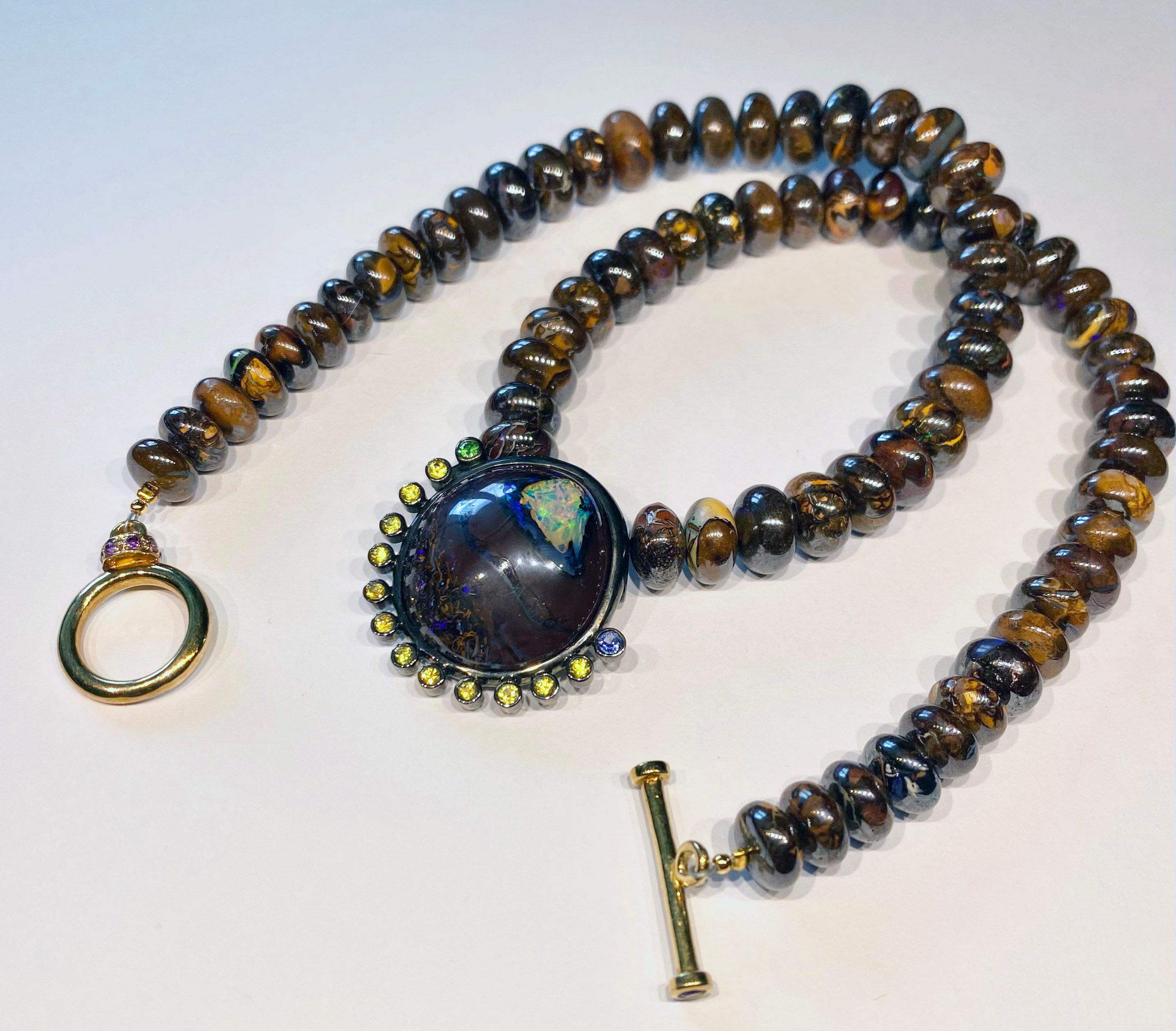 Boulder-Opal, Saphir und Tsavorit-Anhänger an einer Perlen-Opal-Halskette.