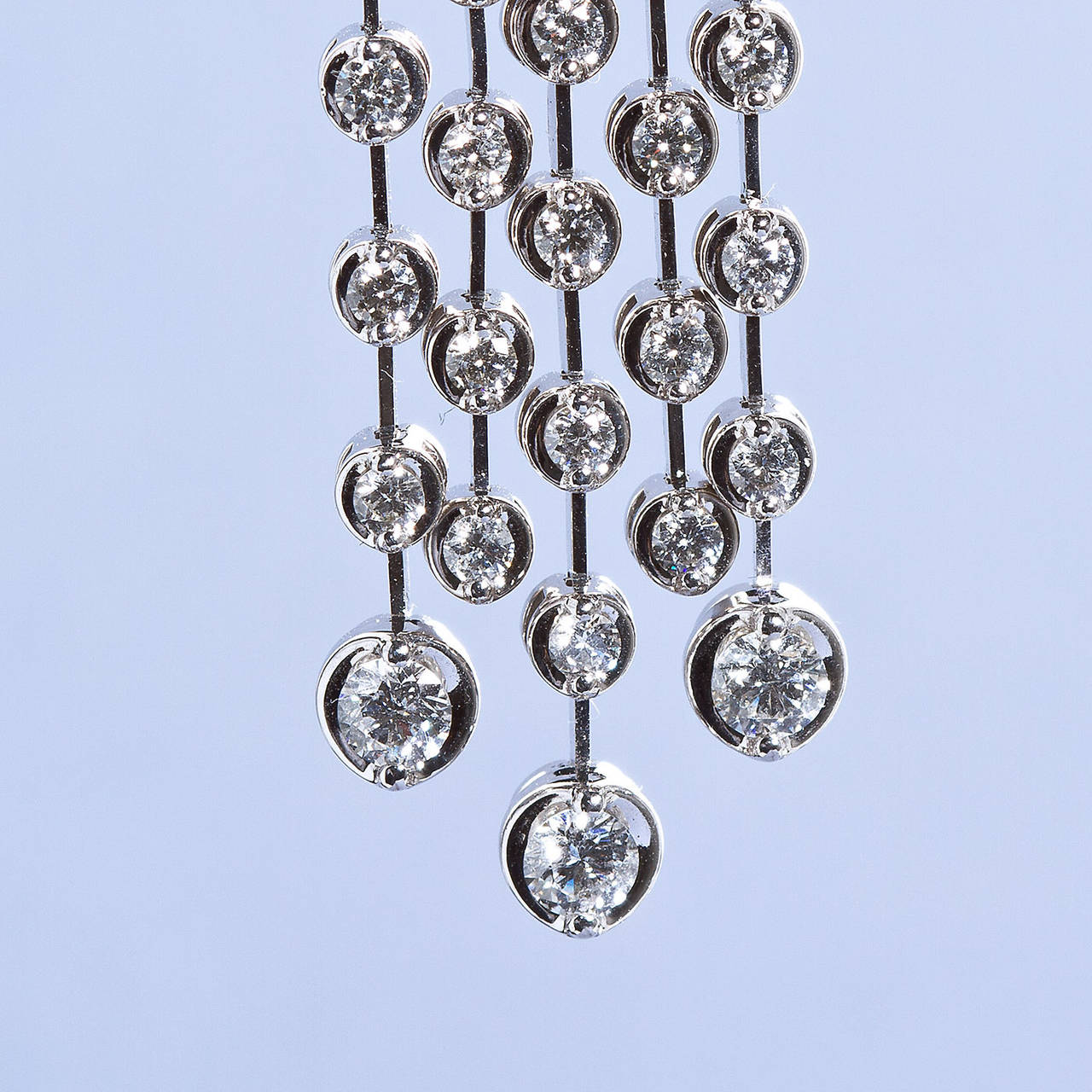 A pair of diamonds spray bezel set modern polished 14kt white gold five-wor chandelier dangle earrings.

Dealer ref No. 6092