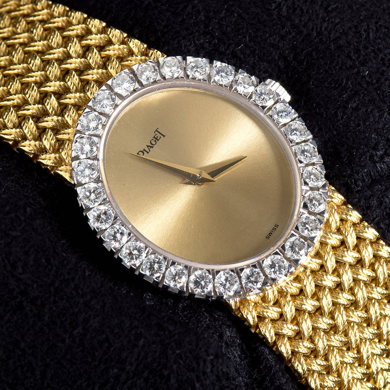 A wonderful rare Piaget woven textured 18 karat gold  bracelet diamond set oval watch. The dial is satin gold and surrounded by over 1.70 carats of 28  fine color bright F color VS quality diamonds. The bracelet is in excellent condition and appears