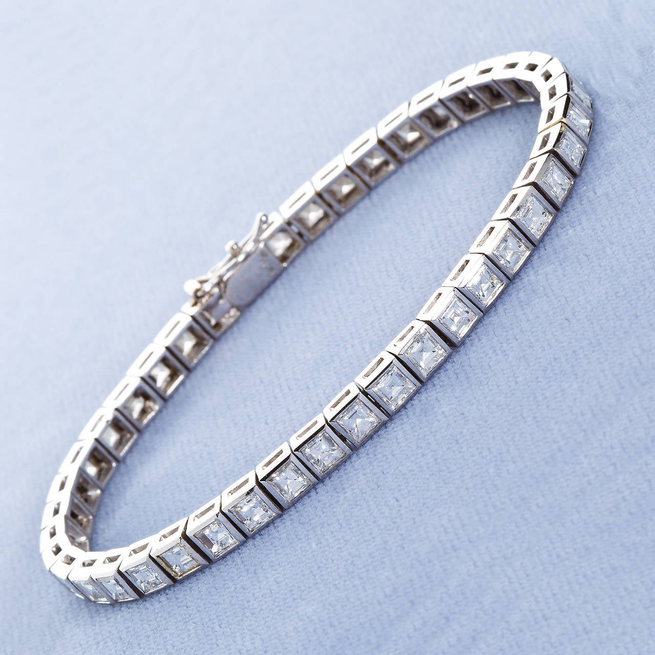 A very fine diamond tennis bracelet in 18k white gold. Square bezel settings contain 42 square step-cut diamonds (approx. 10.00cts.). Very high color and clarity (D-F, VVS-VS). 7