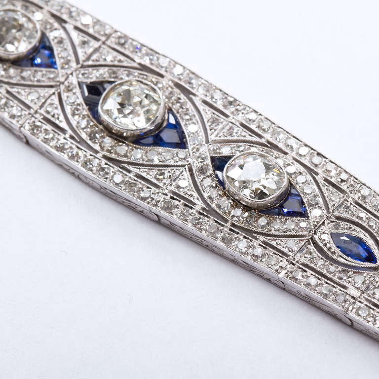 A very fine platinum bracelet inlaid with round cut diamonds and three center old miner diamonds surrounded by a superb swirl design with graduating marquise shaped sapphires.

Dealer ref No. 5811