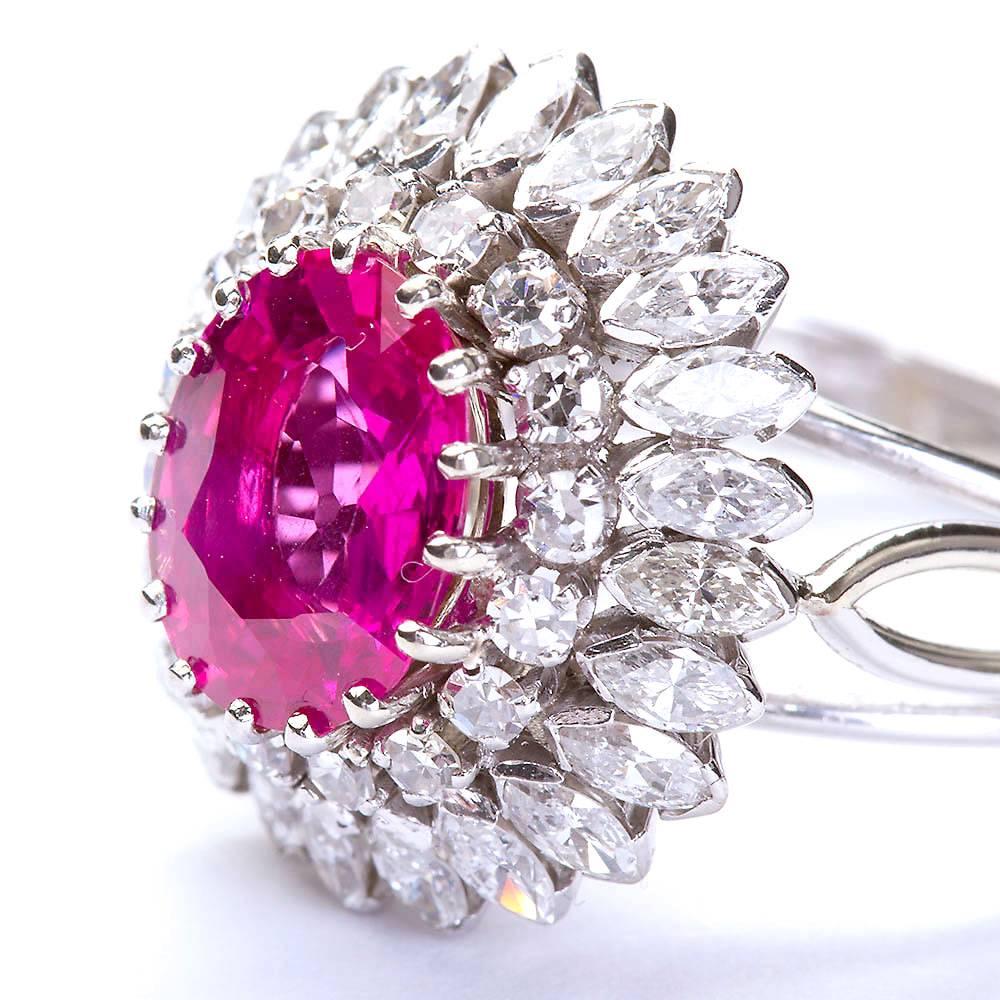 A deep hued 2.33 carats natural no-heat oval pink sapphire in an 18 karat white gold and diamond setting. Diamond double border contains approx 2.00 carats of marquise and round brilliant high color and clarity diamonds.

Resized to fit.

No.