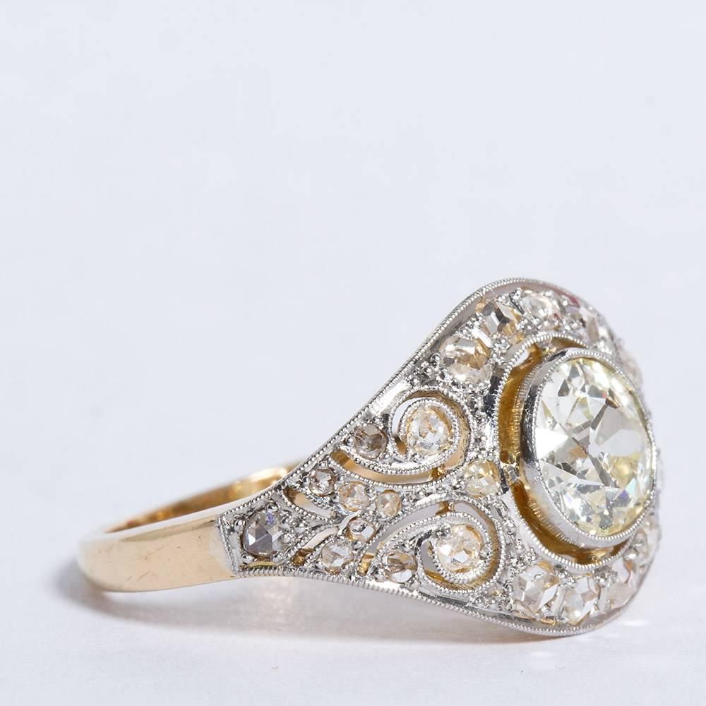 A diamond in platinum and gold ring with Art Deco styling. Distinct filigree and millgraining patterns surround the center stone.  The center is an approximately 1.50 carat I color VS clarity Old European cut diamond.

Ring size 7.25 (resizable to